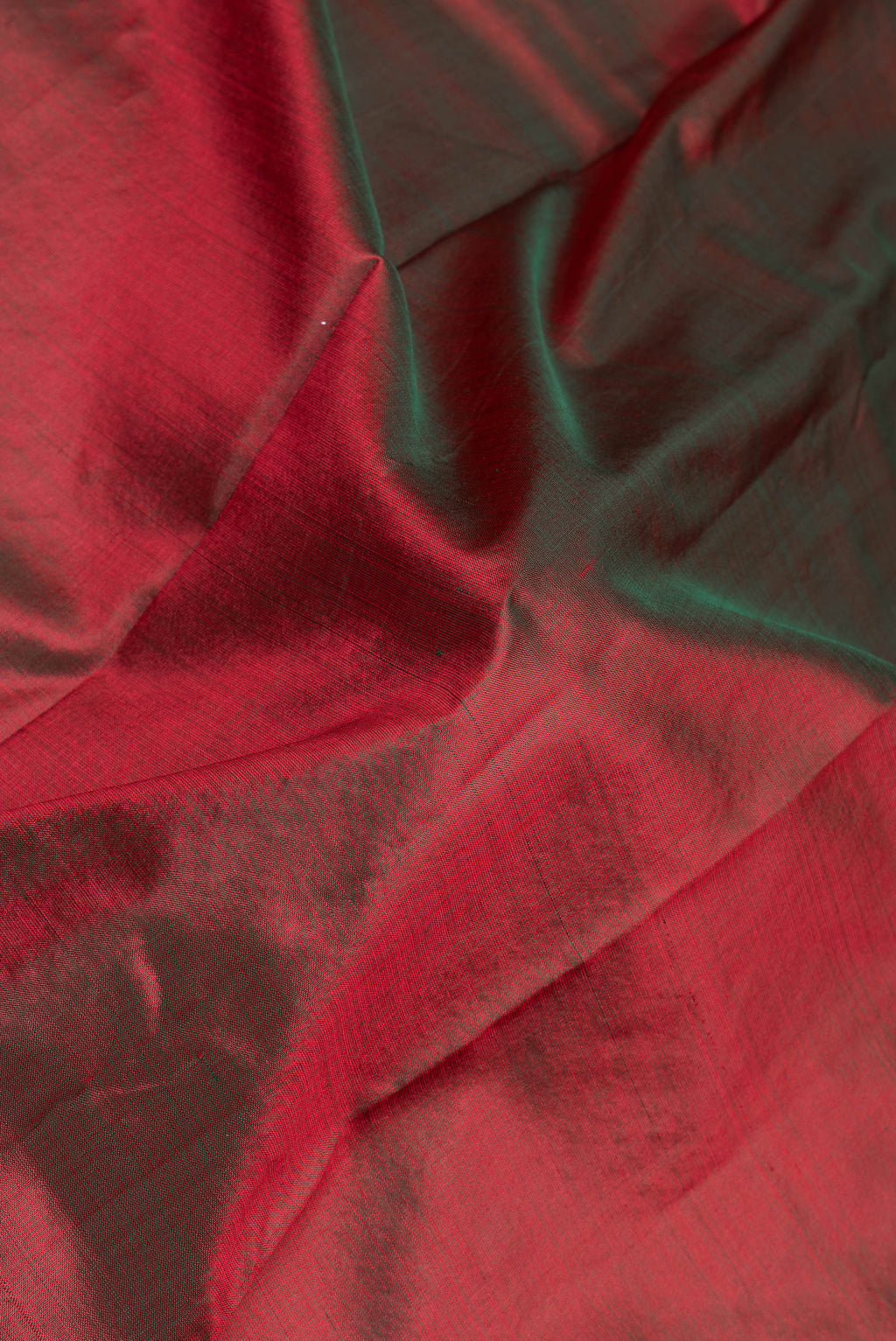 Close up of Maroon Kanchipuram Silk Saree with Plain Body and Zari Border.  displaying folds