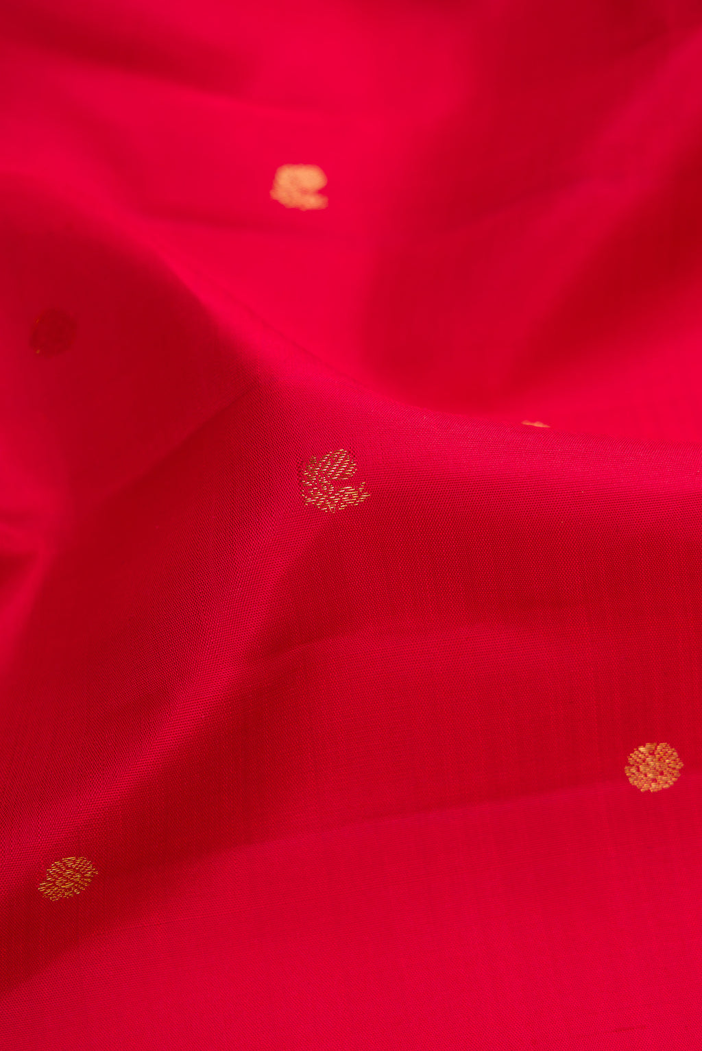 Close up of Red Dual Tone Kanjivaram Silk Saree with Zari Butta on the body and Zari Border.  displaying folds