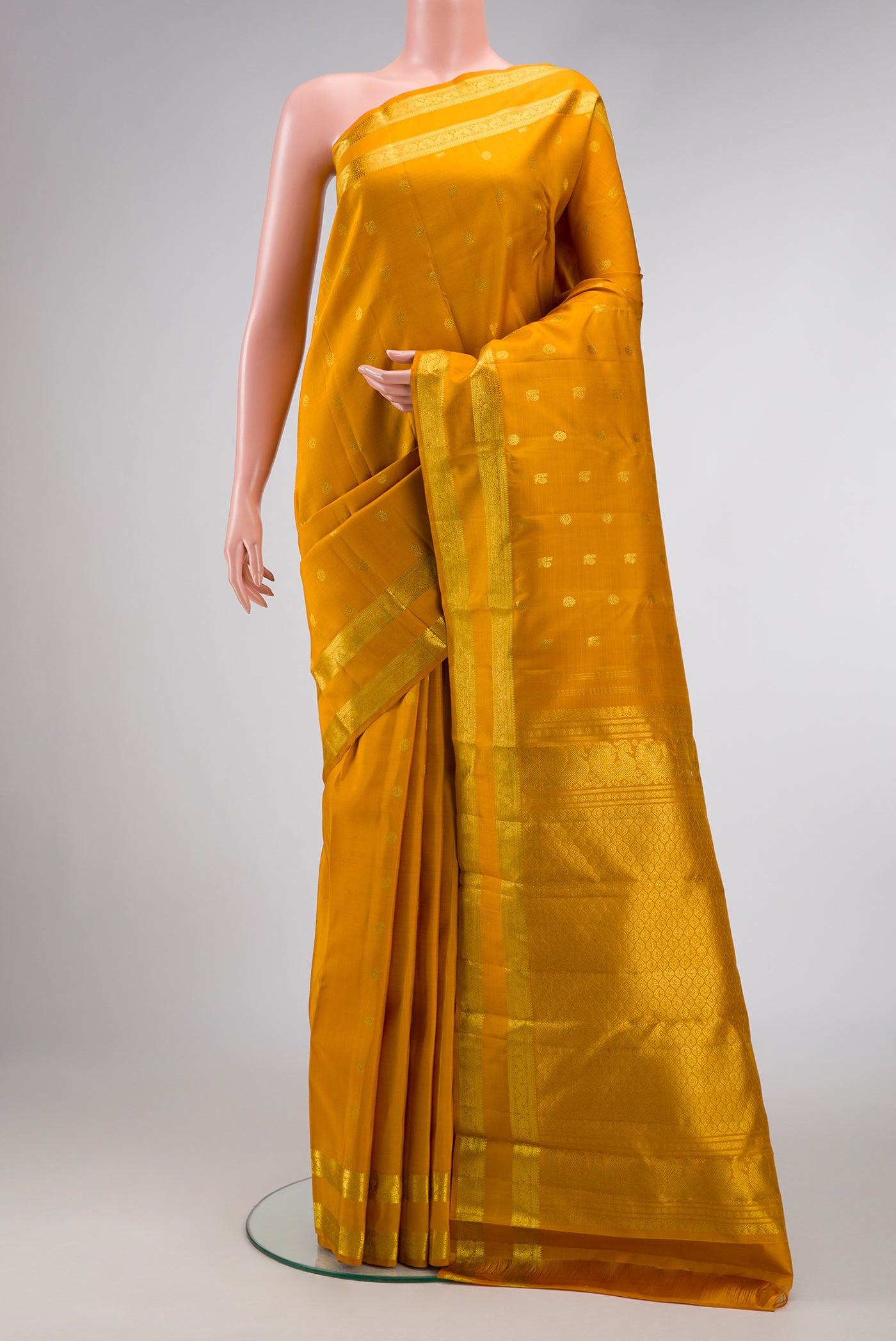 Mustard Dual Tone Kanjivaram Silk Saree with Zari Butta on the body and Zari Border.  displayed on a mannequin