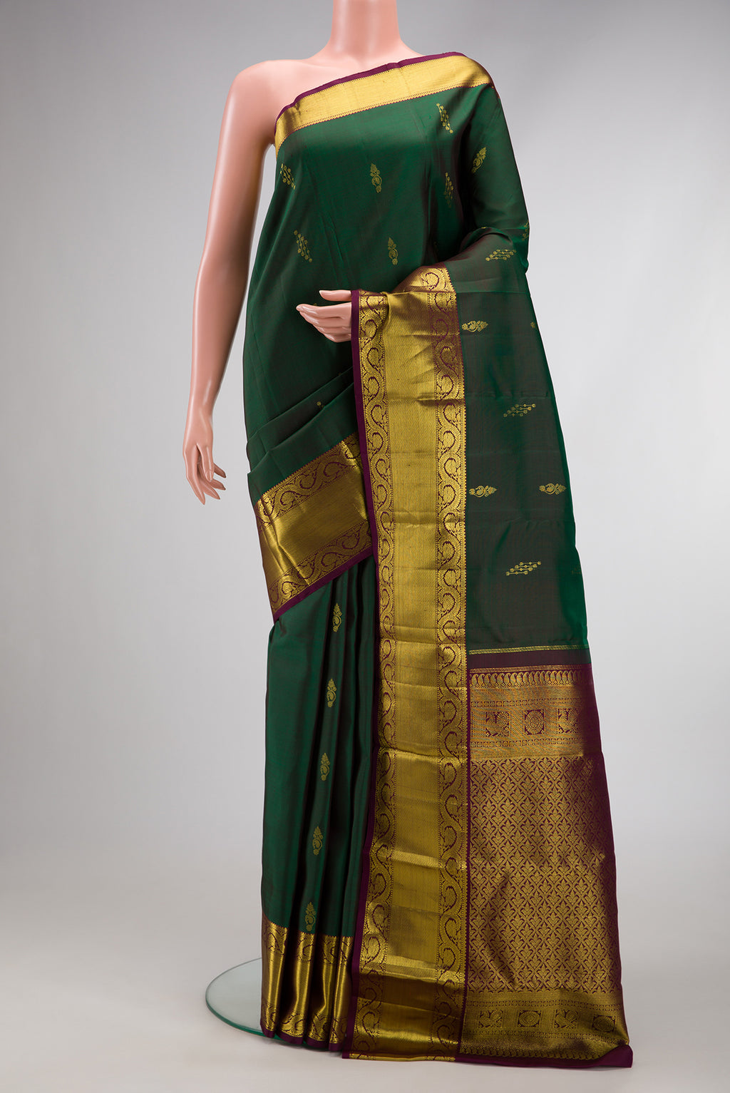 Bottle Green Dual Tone Kanjivaram Silk Saree with Zari Butta on the body and Zari Border.  displayed on a mannequin