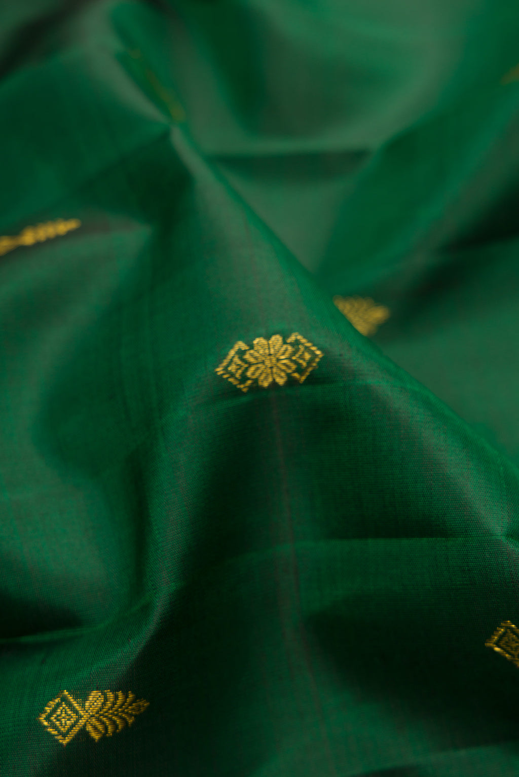 Close up of Bottle Green Dual Tone Kanjivaram Silk Saree with Zari Butta on the body and Zari Border.  displaying folds