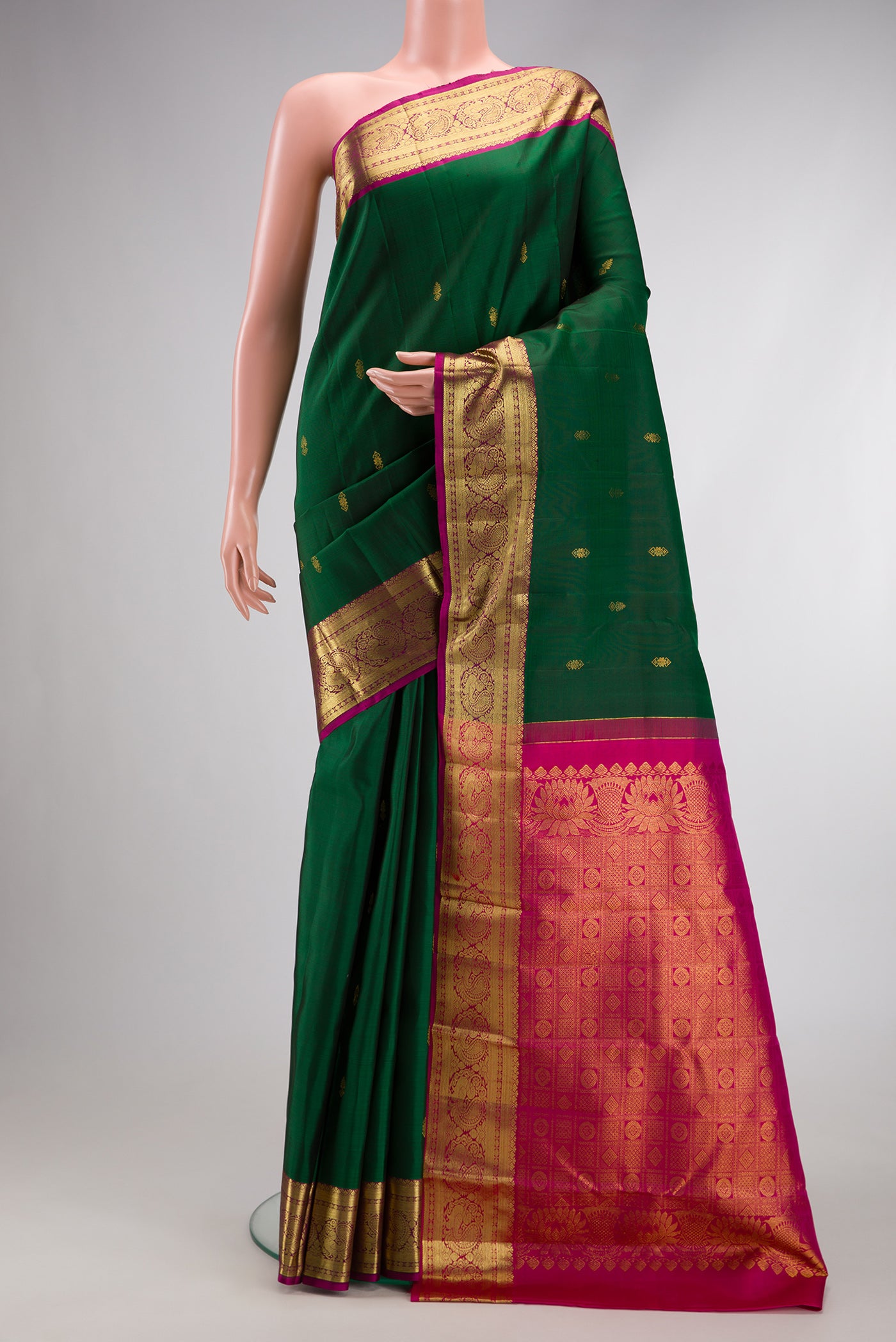 Bottle Green Dual Tone Kanjivaram Silk Saree with Zari Butta on the body and Zari Border.  displayed on a mannequin
