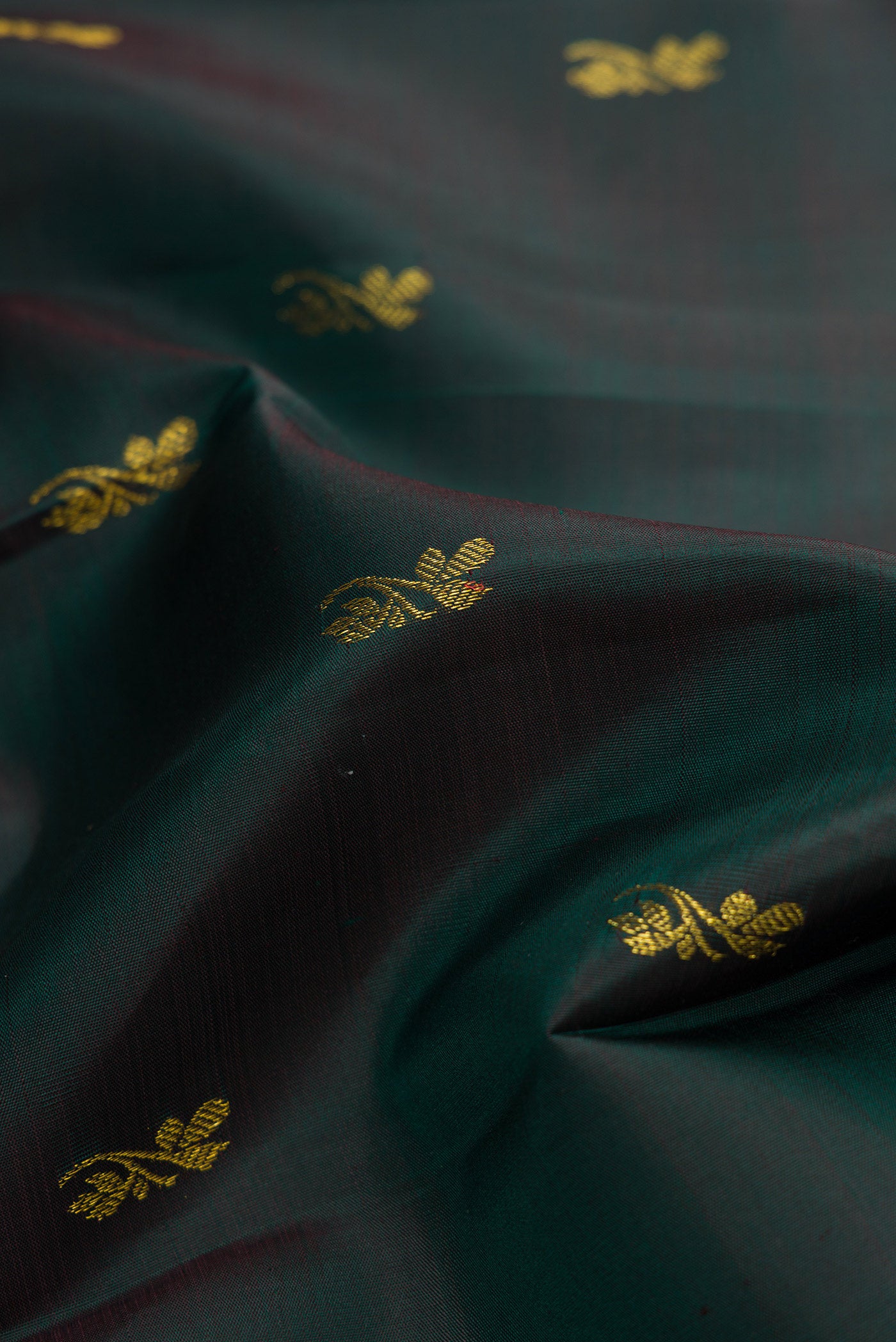 Close up of Bottle Green Dual Tone Kanjivaram Silk Saree with Zari Butta on the body and Zari Border.  displaying folds