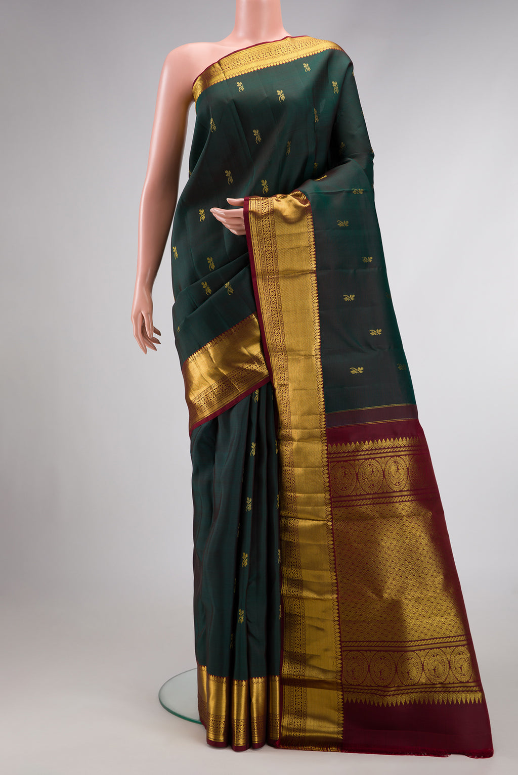 Bottle Green Dual Tone Kanjivaram Silk Saree with Zari Butta on the body and Zari Border.  displayed on a mannequin