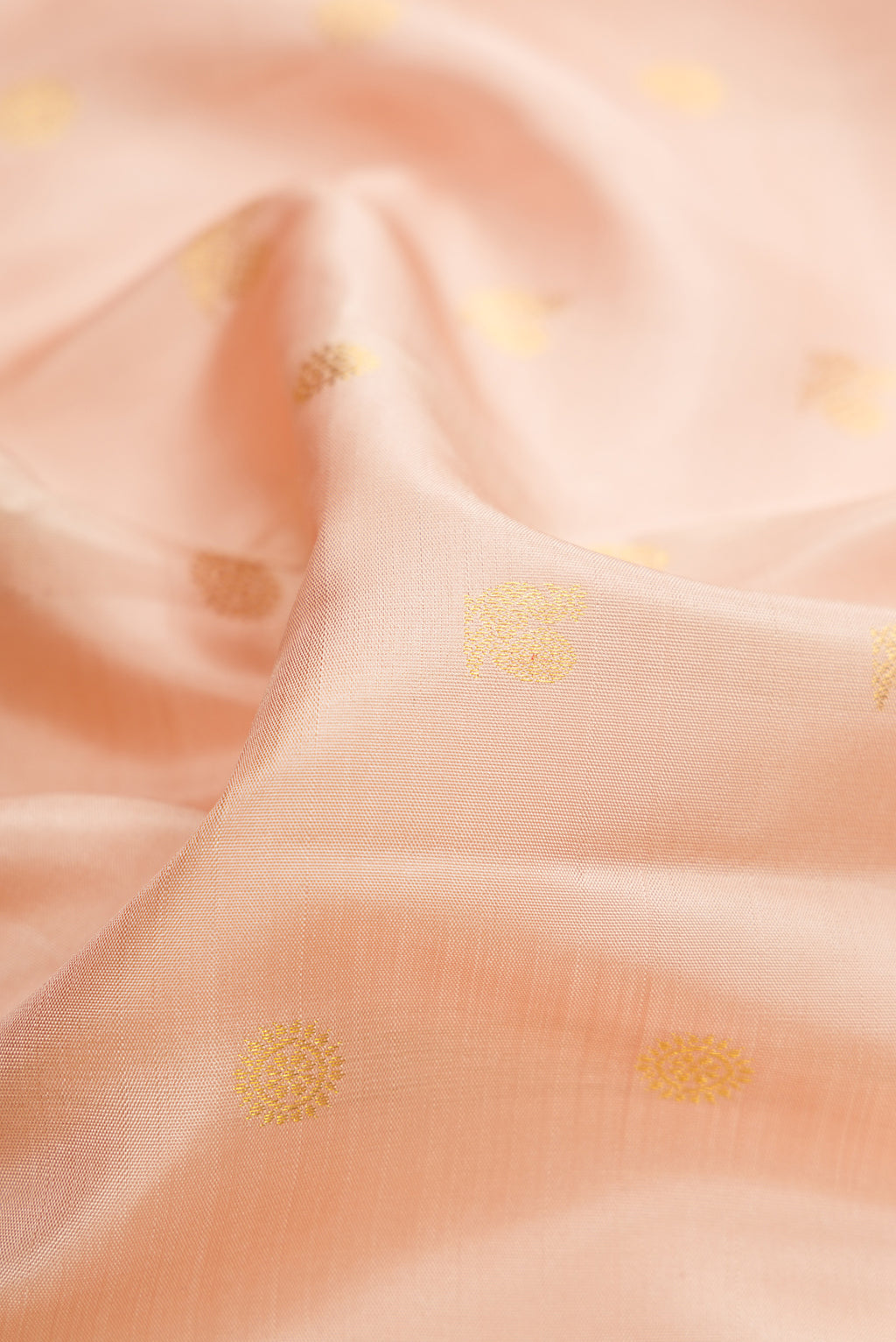 Close up of Beige Dual Tone Kanjivaram Silk Saree with Zari Butta on the body and Zari Border.  displaying folds