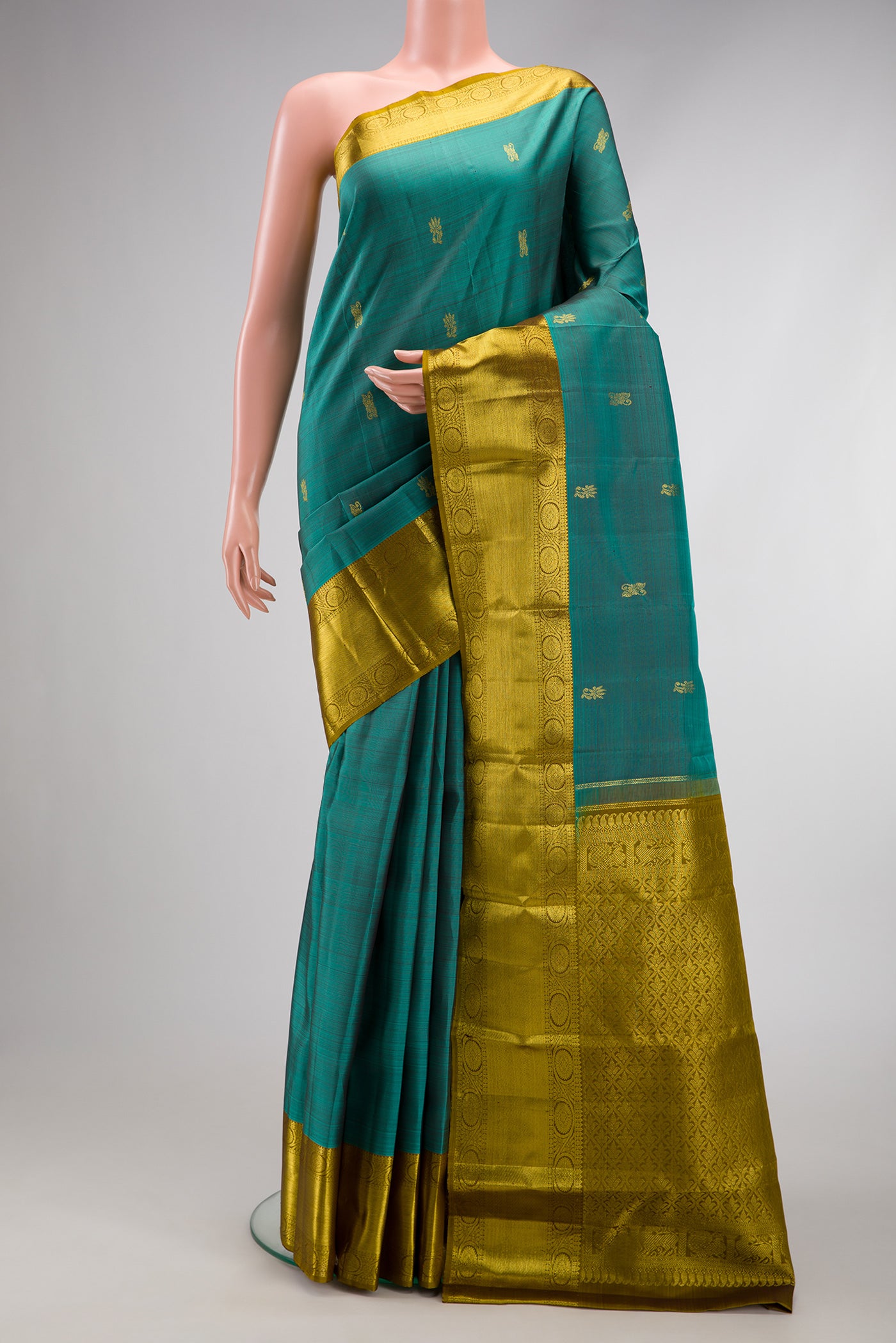 Teal Dual Tone Kanjivaram Silk Saree with Zari Butta on the body and Zari Border.  displayed on a mannequin