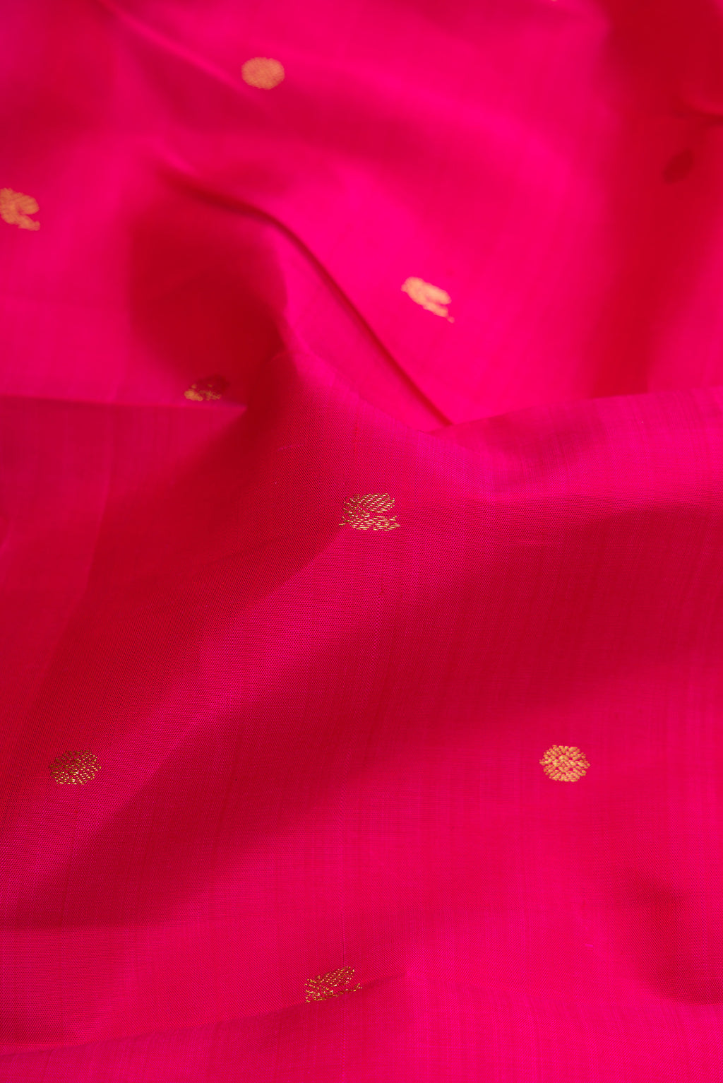 Close up of Dark Pink Dual Tone Kanjivaram Silk Saree with Zari Butta on the body and Zari Border.  displaying folds