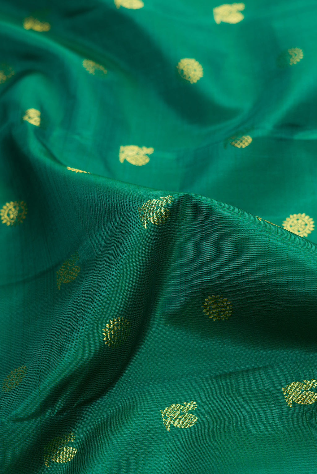 Close up of Green Dual Tone Kanjivaram Silk Saree with Zari Butta on the body and Zari Border.  displaying folds