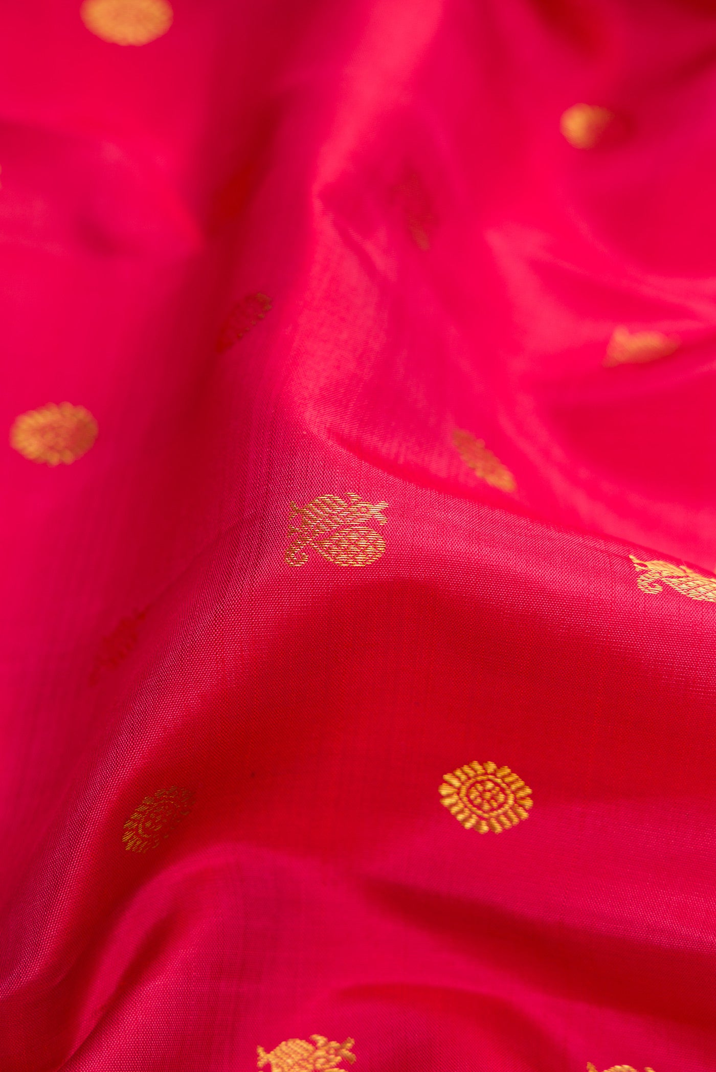 Close up of Dark Pink Dual Tone Kanjivaram Silk Saree with Zari Butta on the body and Zari Border.  displaying folds