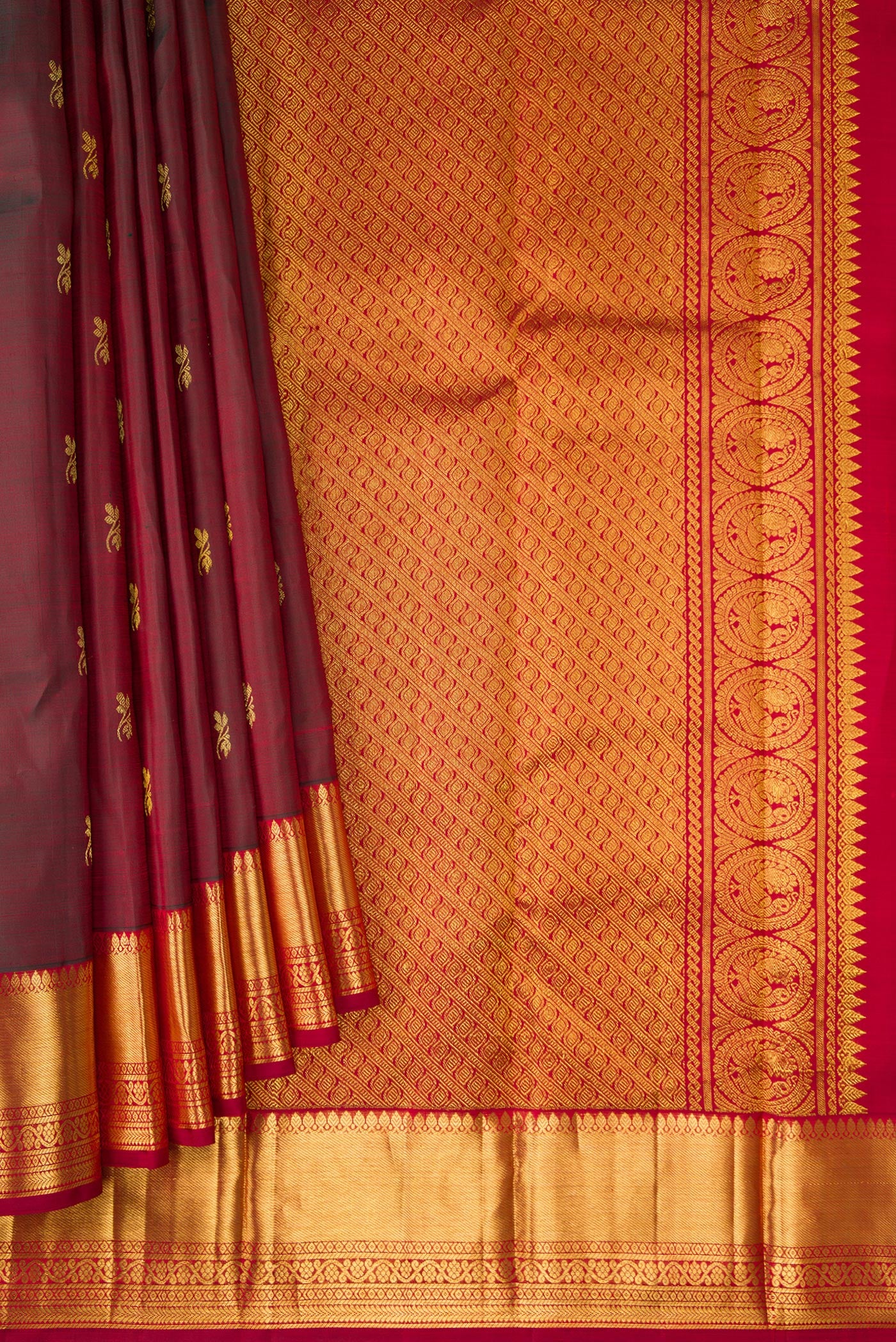 Pleats and pallu of Maroon Dual Tone Kanjivaram Silk Saree with Zari Butta on the body and Zari Border. 