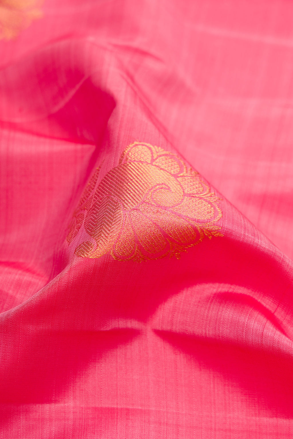 Close up of Pink Dual Tone Kanchipuram Silk Saree with Zari Butta on the body and Zari Border.  displaying folds