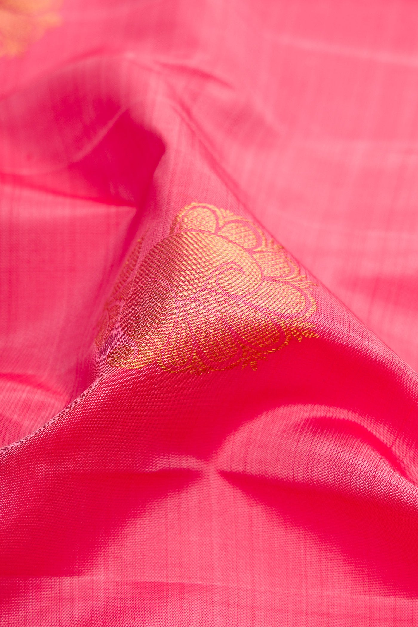 Close up of Pink Dual Tone Kanchipuram Silk Saree with Zari Butta on the body and Zari Border.  displaying folds