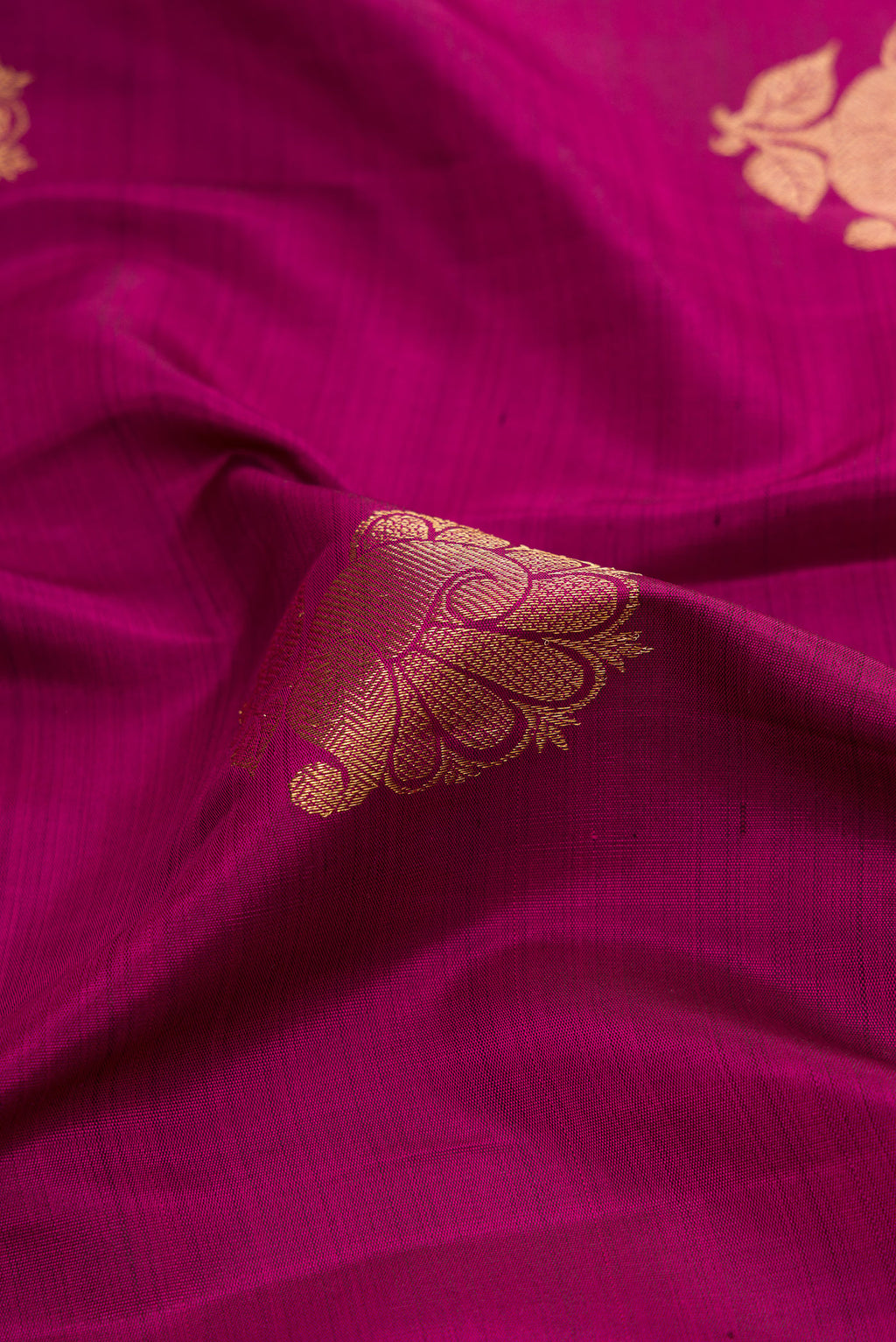 Close up of Magenta Dual Tone Kanchipuram Silk Saree with Zari Butta on the body and Zari Border.  displaying folds