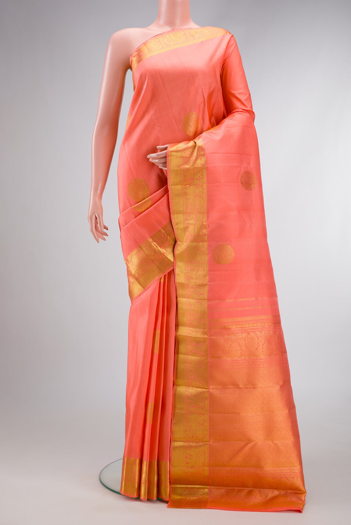 Peach Dual Tone Kanjivaram Silk Saree with Zari Butta on the body and Zari Border.  displayed on a mannequin