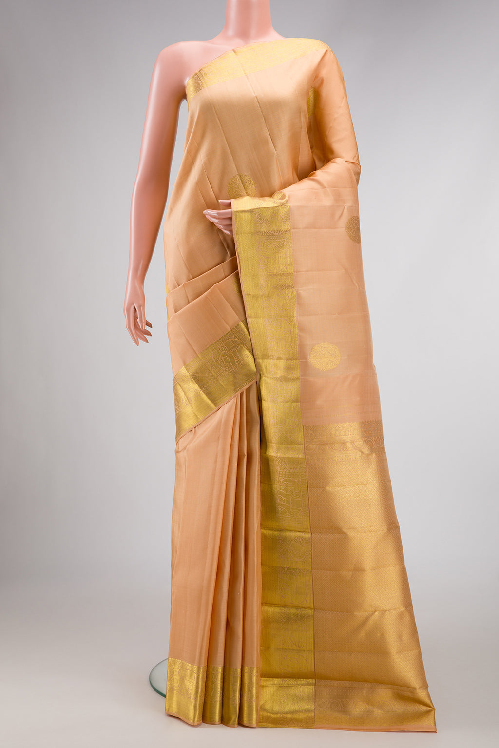 Golden Peach Dual Tone Kanjivaram Silk Saree with Zari Butta on the body and Zari Border.  displayed on a mannequin