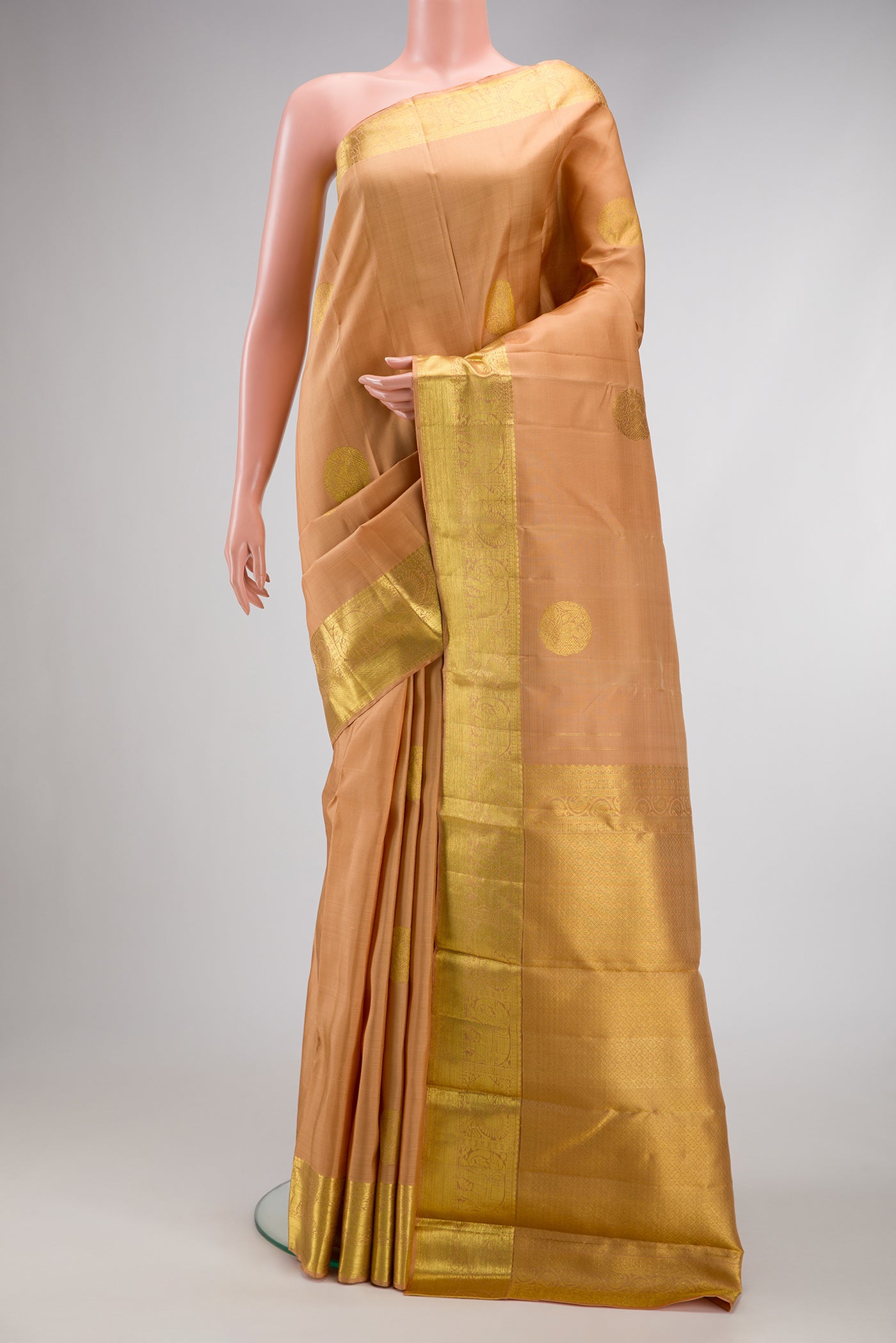 Peach Dual Tone Kanjivaram Silk Saree with Zari Butta on the body and Zari Border.  displayed on a mannequin