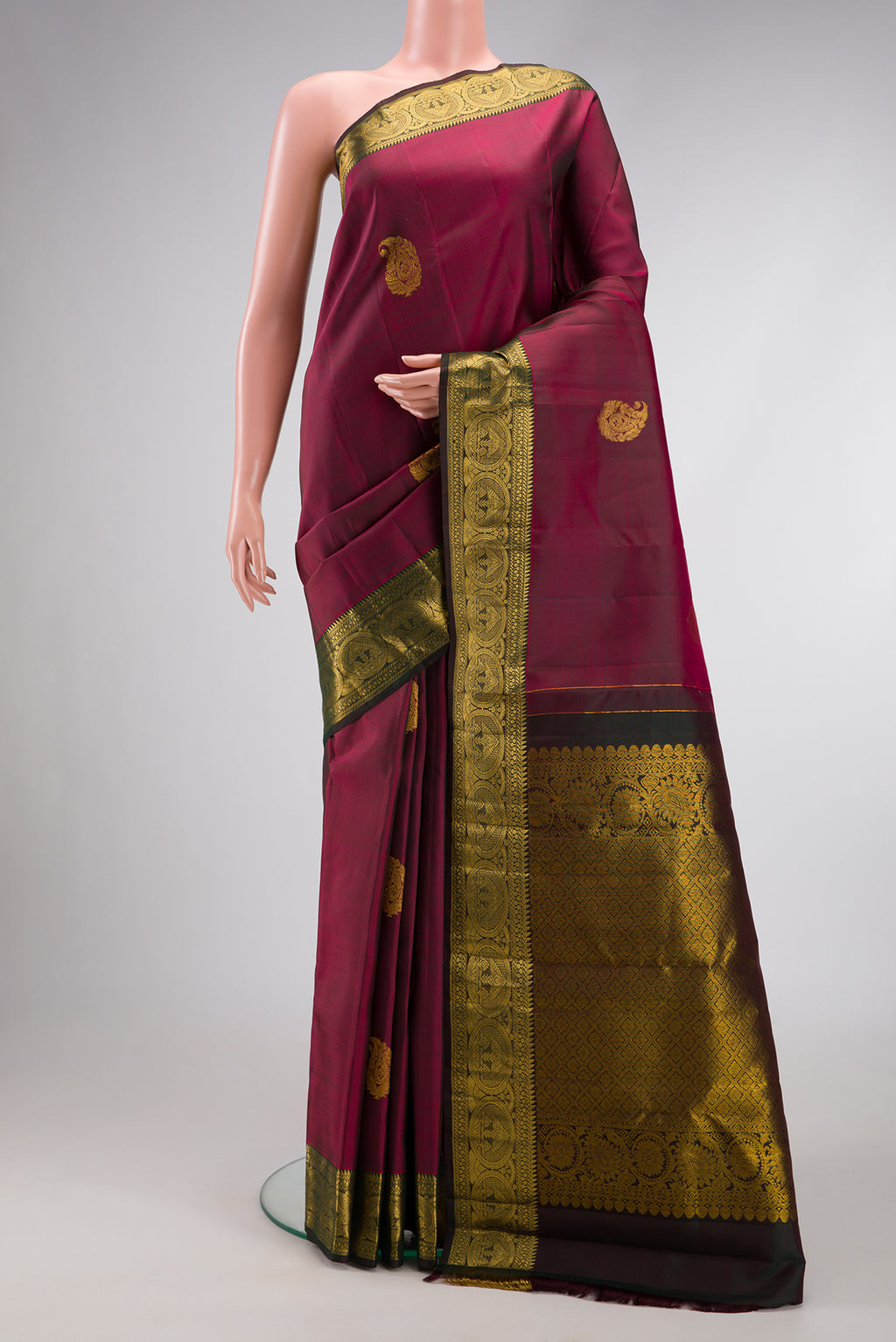 Burgundy Dual Tone Kanjivaram Silk Saree with Zari Butta on the body and Zari Border.  displayed on a mannequin