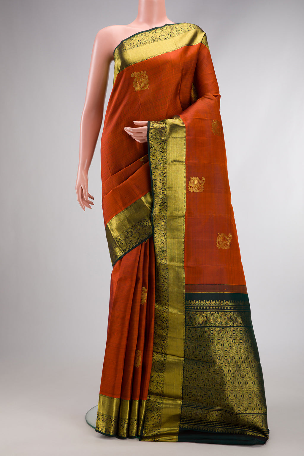 Brick Orange Dual Tone Kanjivaram Silk Saree with Zari Butta on the body and Zari Border.  displayed on a mannequin