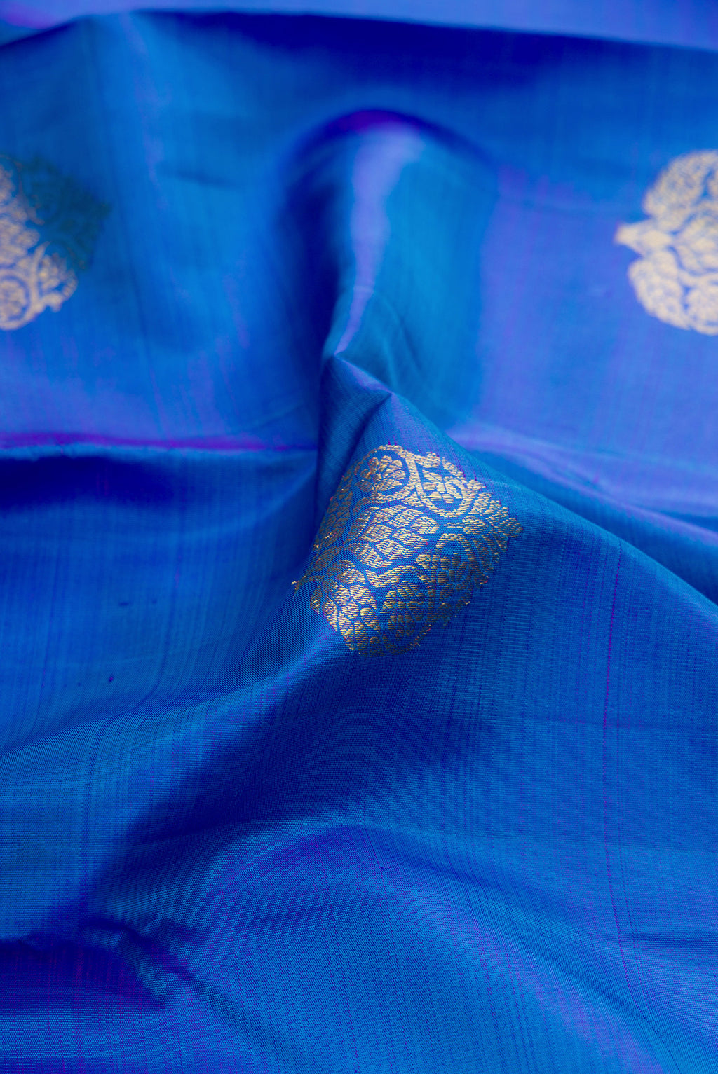 Close up of Royal Blue Dual Tone Kanjivaram Silk Saree with Zari Butta on the body and Zari Border.  displaying folds