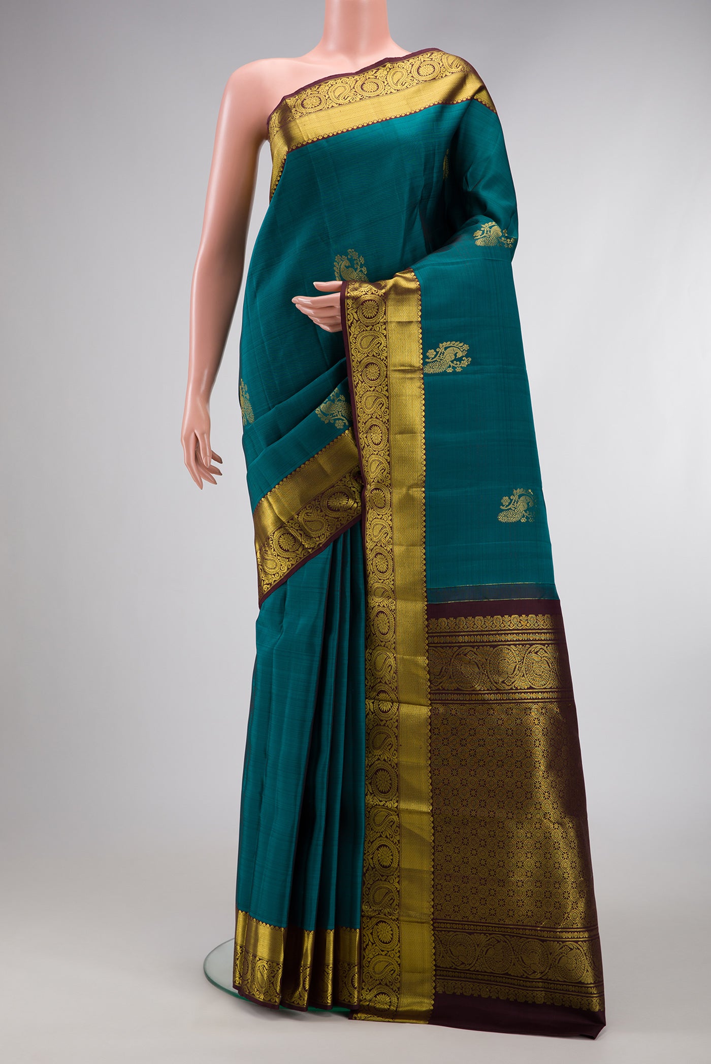 Teal Dual Tone Kanjivaram Silk Saree with Zari Butta on the body and Zari Border.  displayed on a mannequin