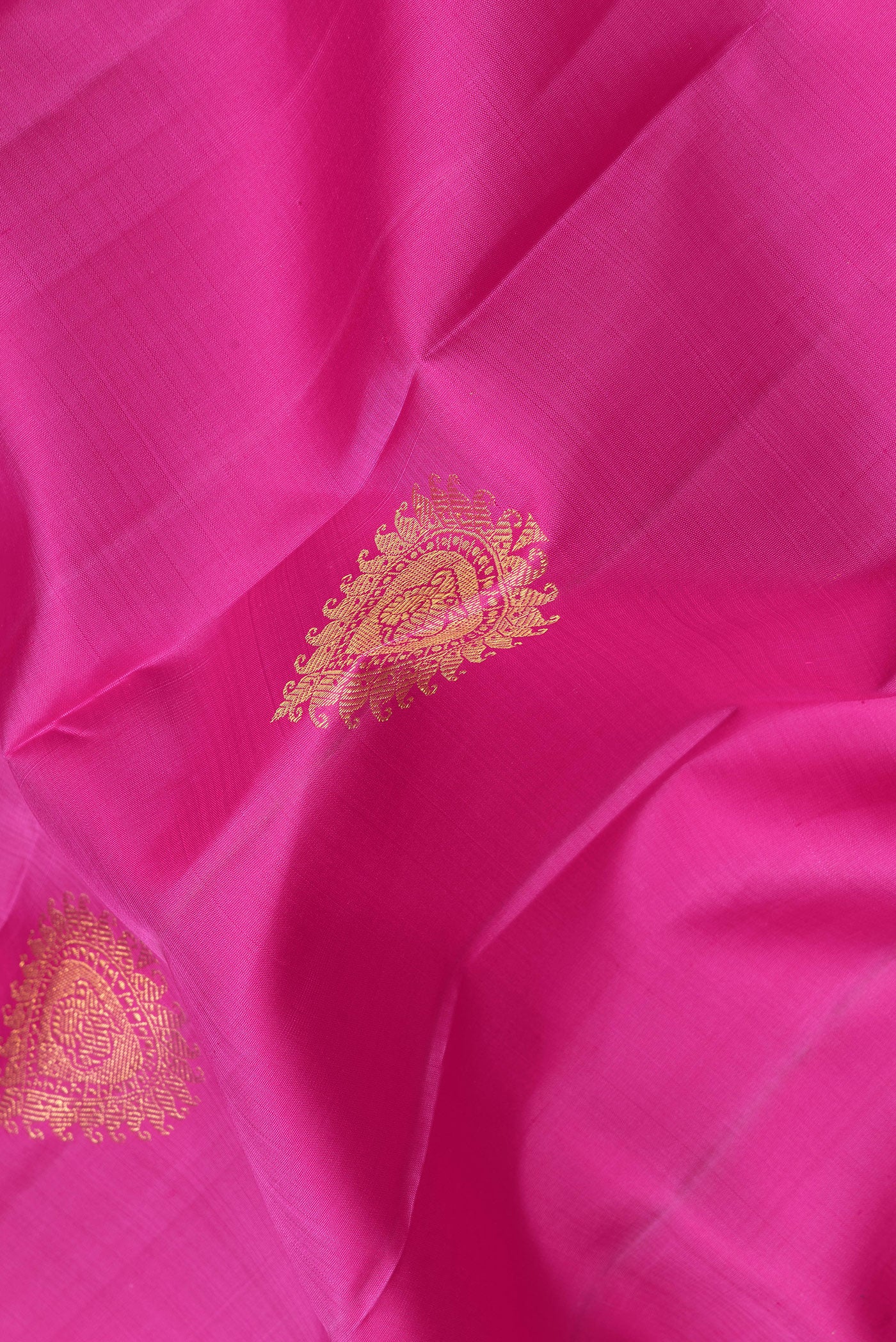 Close up of Pink Dual Tone Kanjivaram Silk Saree with Zari Butta on the body and Zari Border.  displaying folds