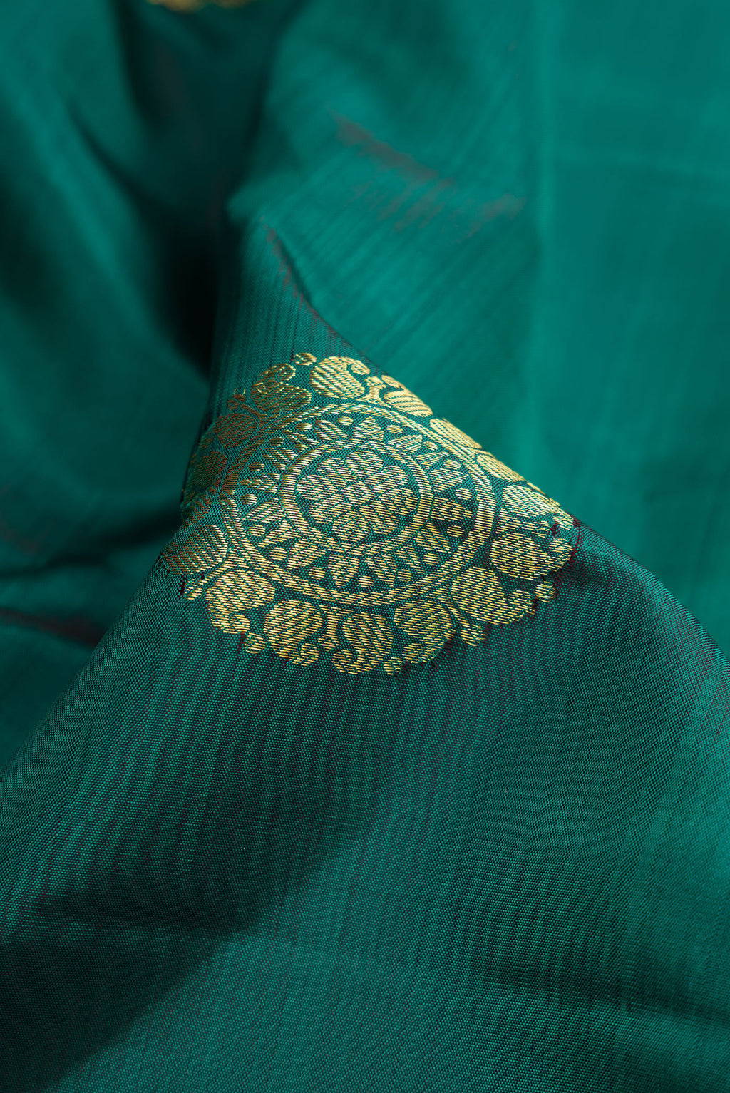 Close up of Bottle Green Dual Tone Kanjivaram Silk Saree with Zari Butta on the body and Zari Border.  displaying folds
