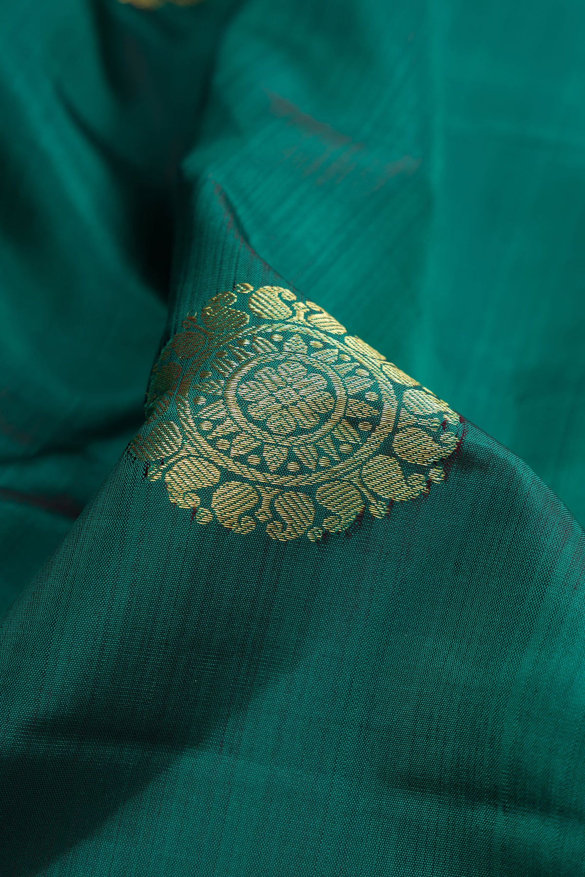 Close up of Bottle Green Dual Tone Kanjivaram Silk Saree with Zari Butta on the body and Zari Border.  displaying folds