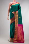 Bottle Green Dual Tone Kanjivaram Silk Saree with Zari Butta on the body and Zari Border.  displayed on a mannequin