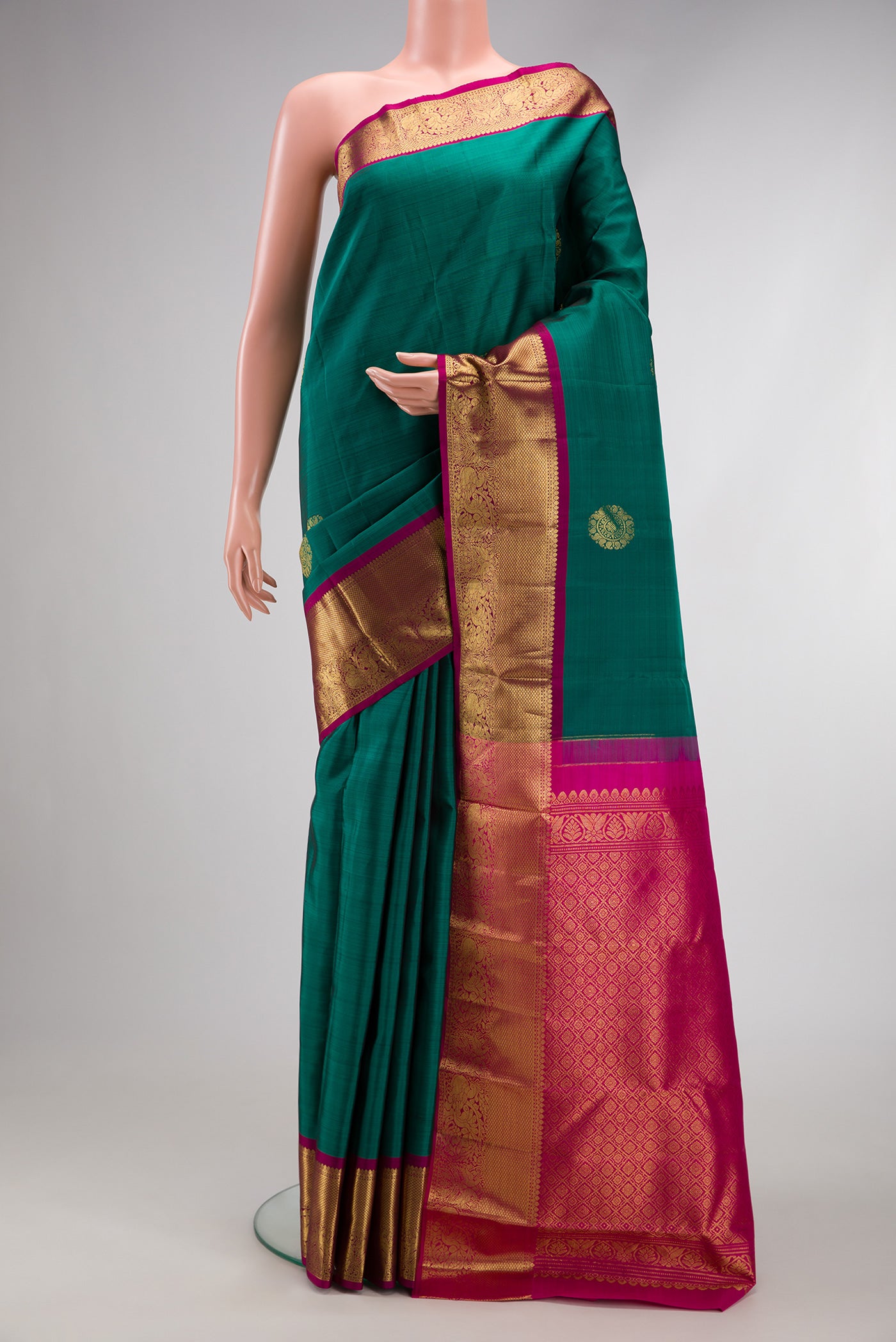 Bottle Green Dual Tone Kanjivaram Silk Saree with Zari Butta on the body and Zari Border.  displayed on a mannequin