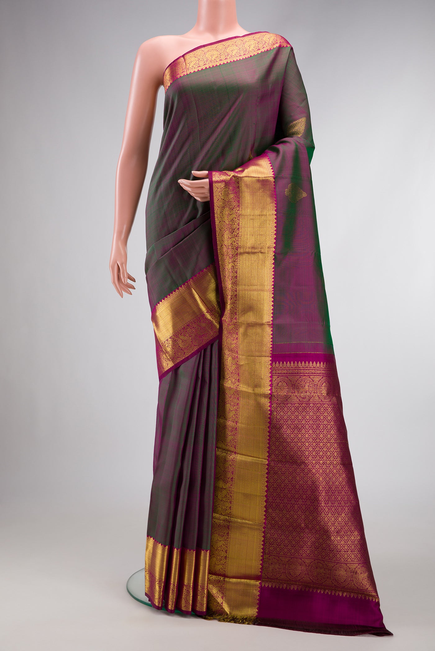 Bottle Green Dual Tone Kanjivaram Silk Saree with Zari Butta on the body and Zari Border.  displayed on a mannequin