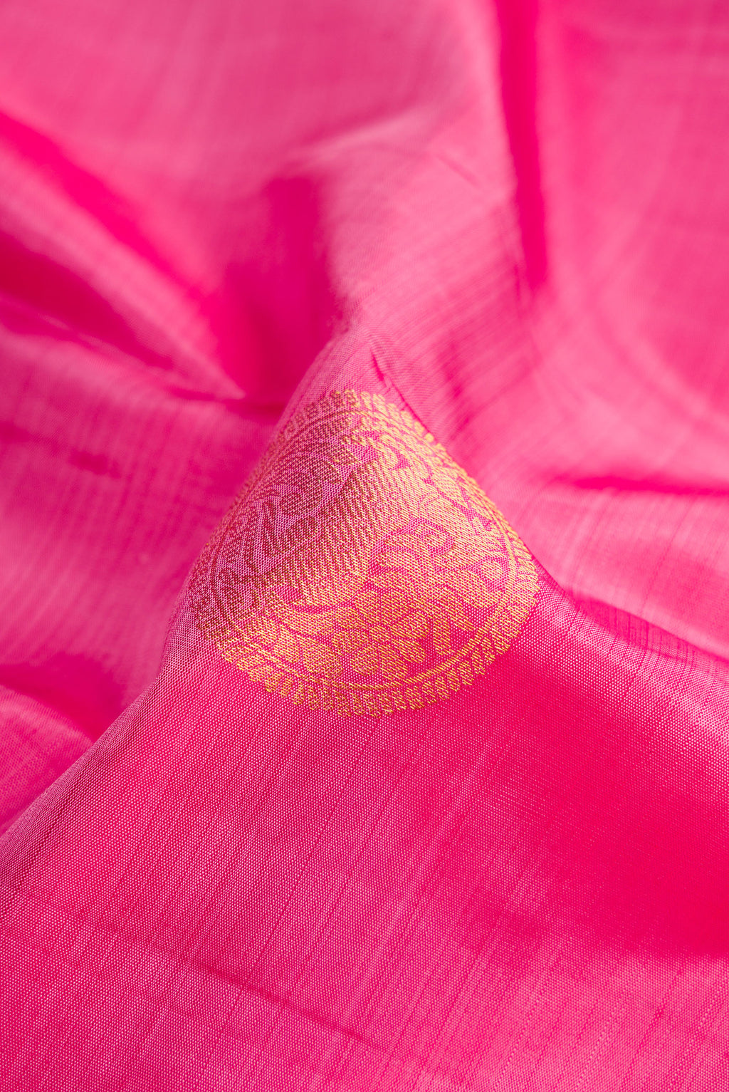 Close up of Pink Kanjivaram Silk Saree with Zari Butta on the body and Zari Border.  displaying folds