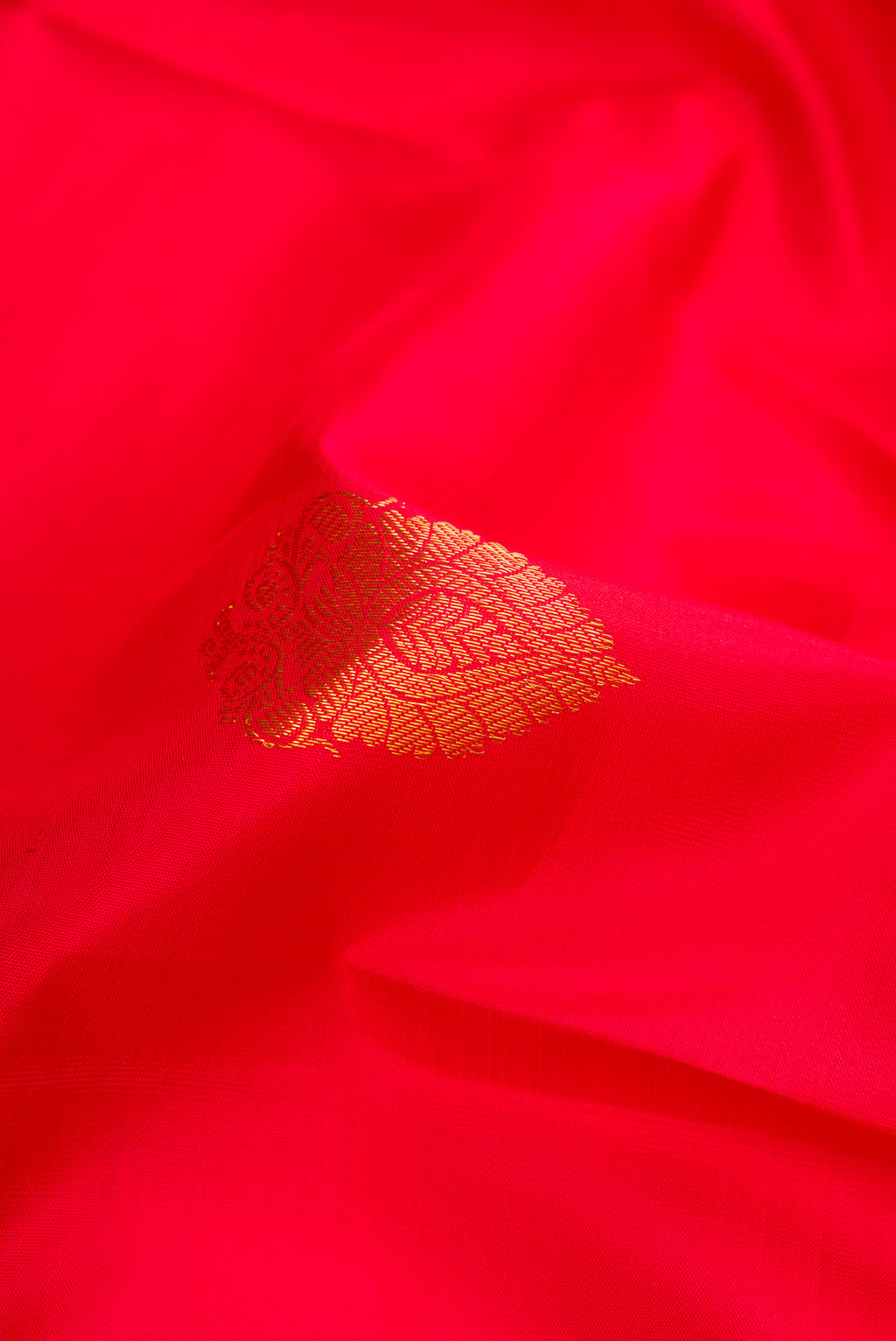 Close up of Red Dual Tone Kanjivaram Silk Saree with Zari Butta on the body and Zari Border.  displaying folds