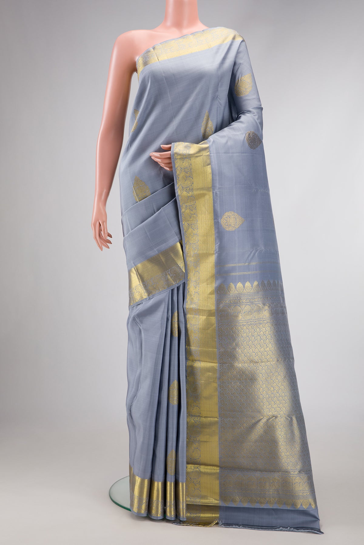 Grey Dual Tone Kanjivaram Silk Saree with Zari Butta on the body and Zari Border.  displayed on a mannequin