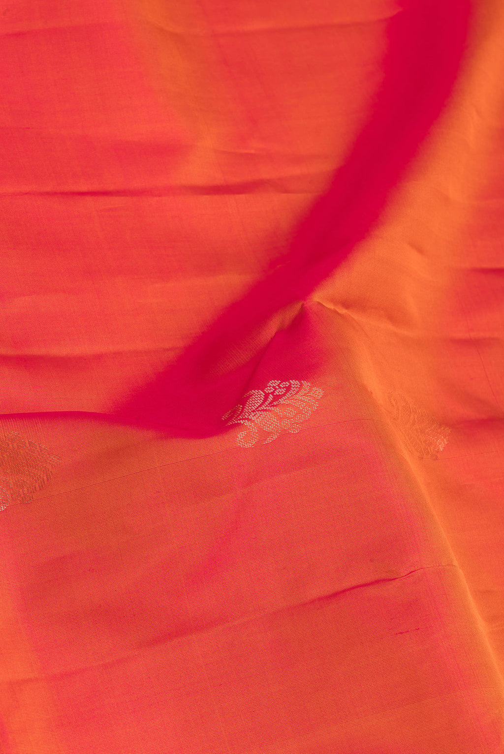 Close up of Brick Orange Soft Silk Saree with Zari Butta on the body and Fancy Border.  displaying folds