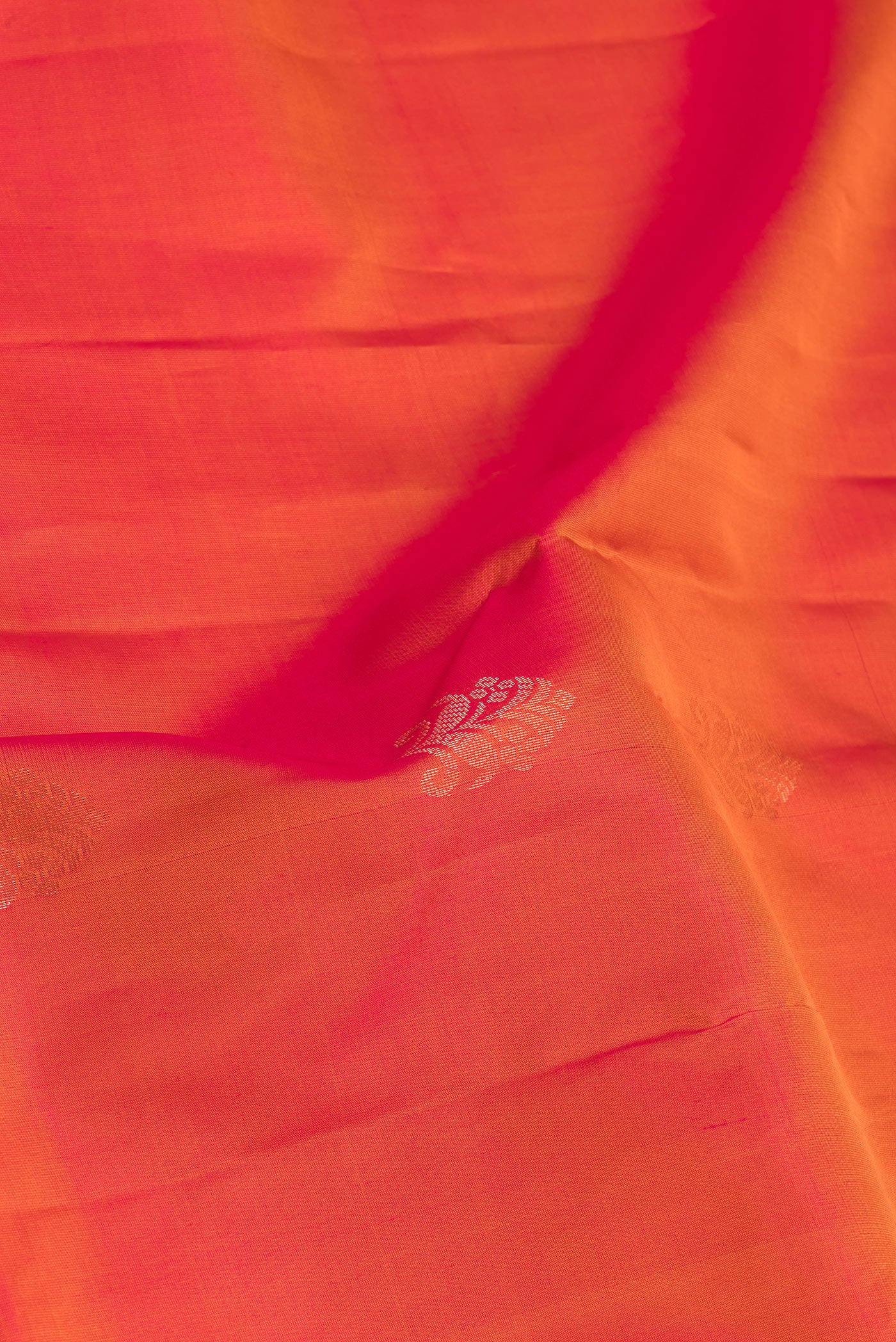 Close up of Brick Orange Soft Silk Saree with Zari Butta on the body and Fancy Border.  displaying folds