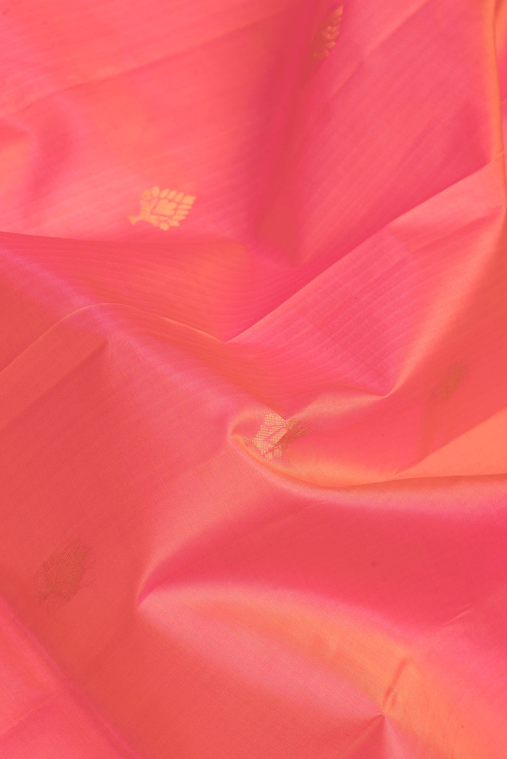 Close up of Coral Dual Tone Soft Silk Saree with Zari Butta on the body and Fancy Border.  displaying folds