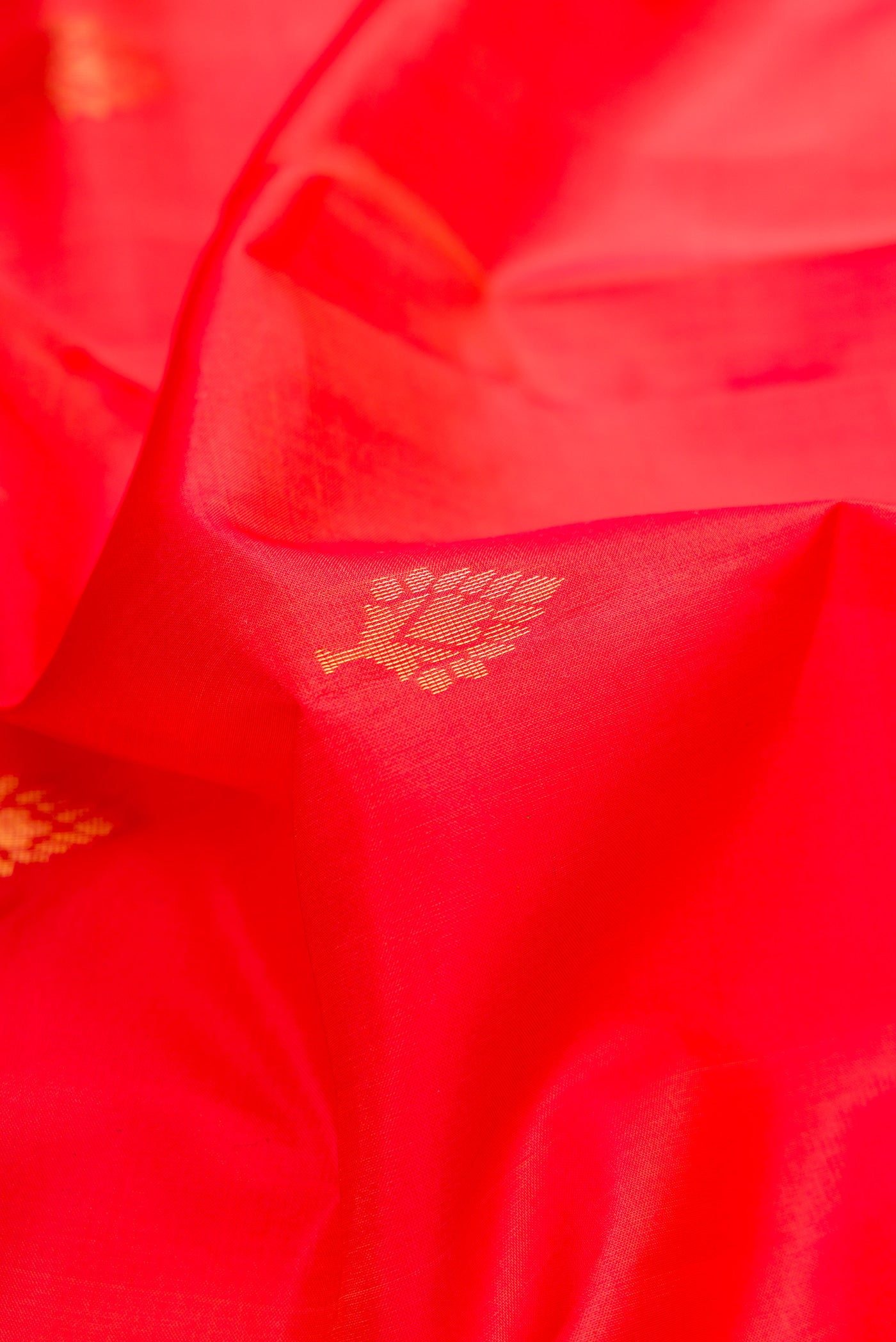 Close up of Brick Orange Dual Tone Soft Silk Saree with Zari Butta on the body and Fancy Border.  displaying folds