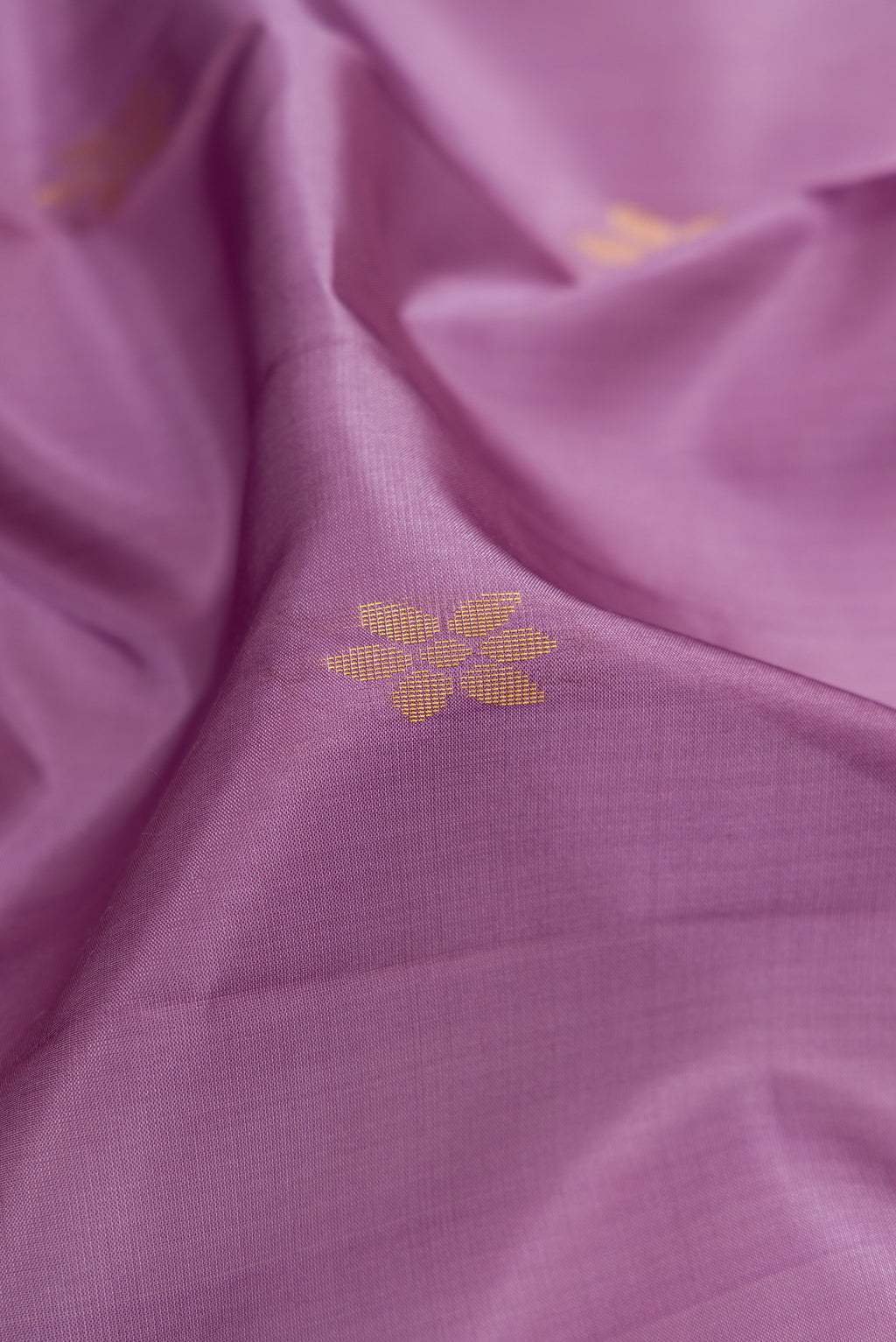 Close up of Lilac Soft Silk Saree with Zari Butta on the body and Zari Border.  displaying folds