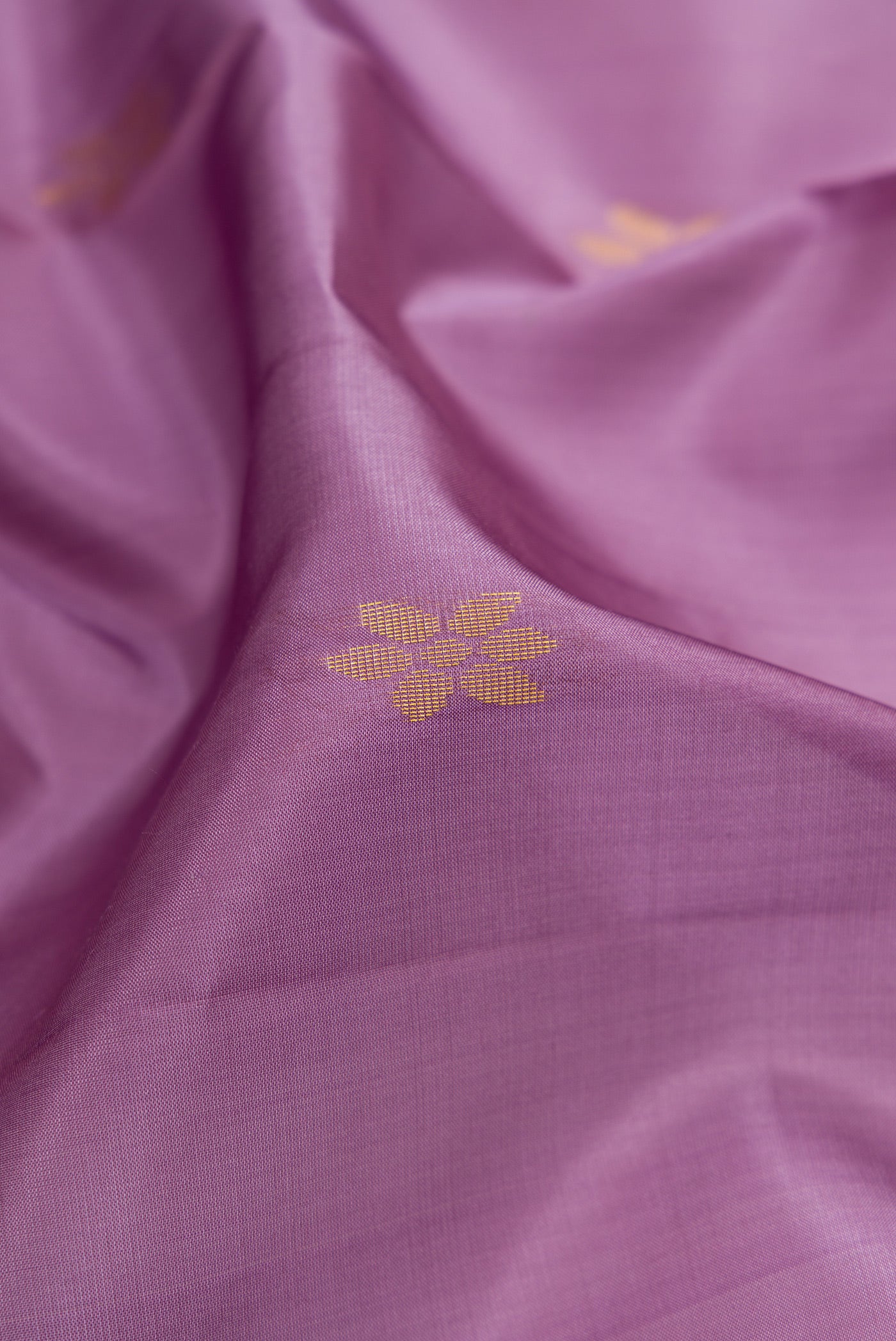 Close up of Lilac Soft Silk Saree with Zari Butta on the body and Zari Border.  displaying folds