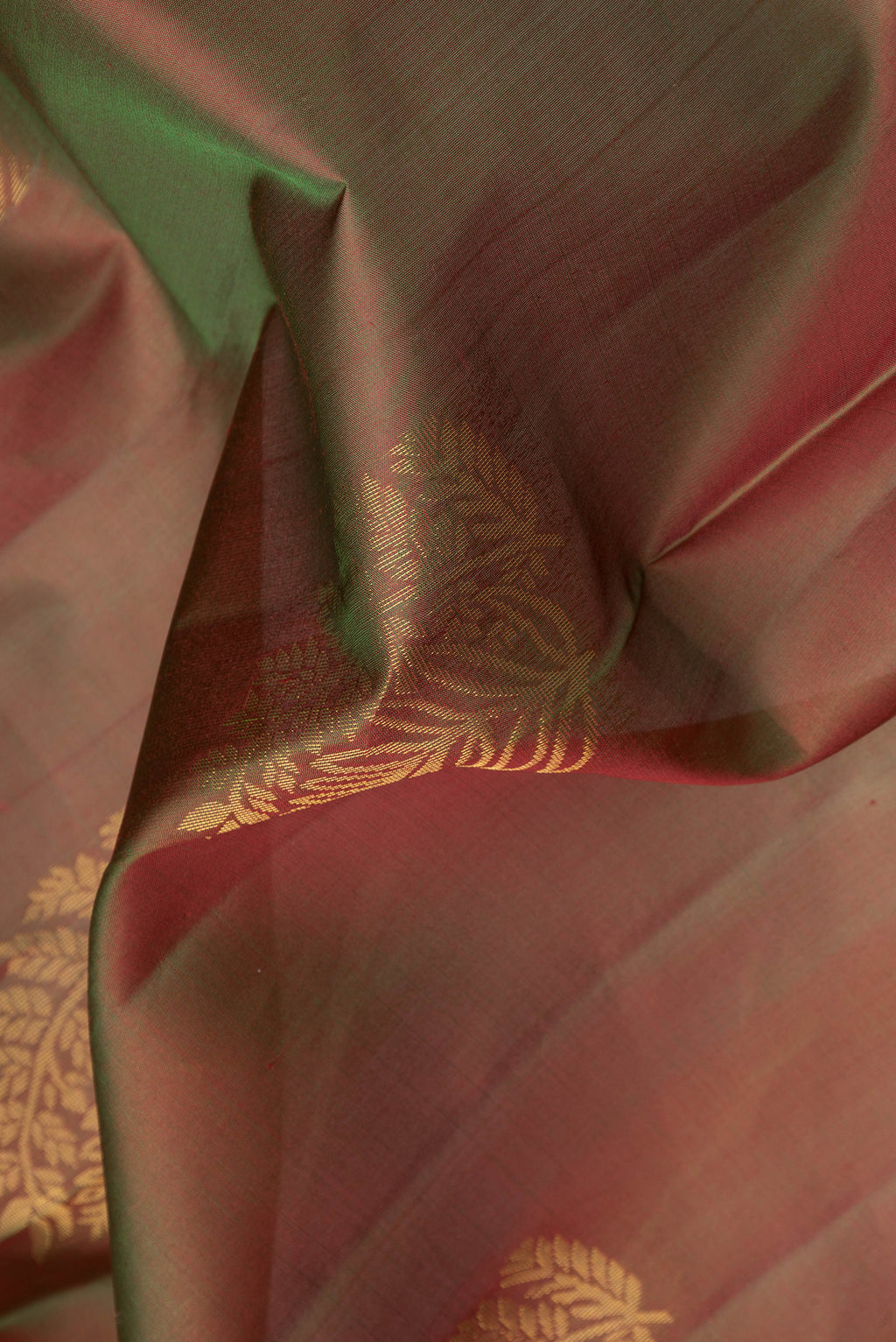Close up of Mehandi Green Dual Tone Soft Silk Saree with Zari Butta on the body and Zari Border.  displaying folds