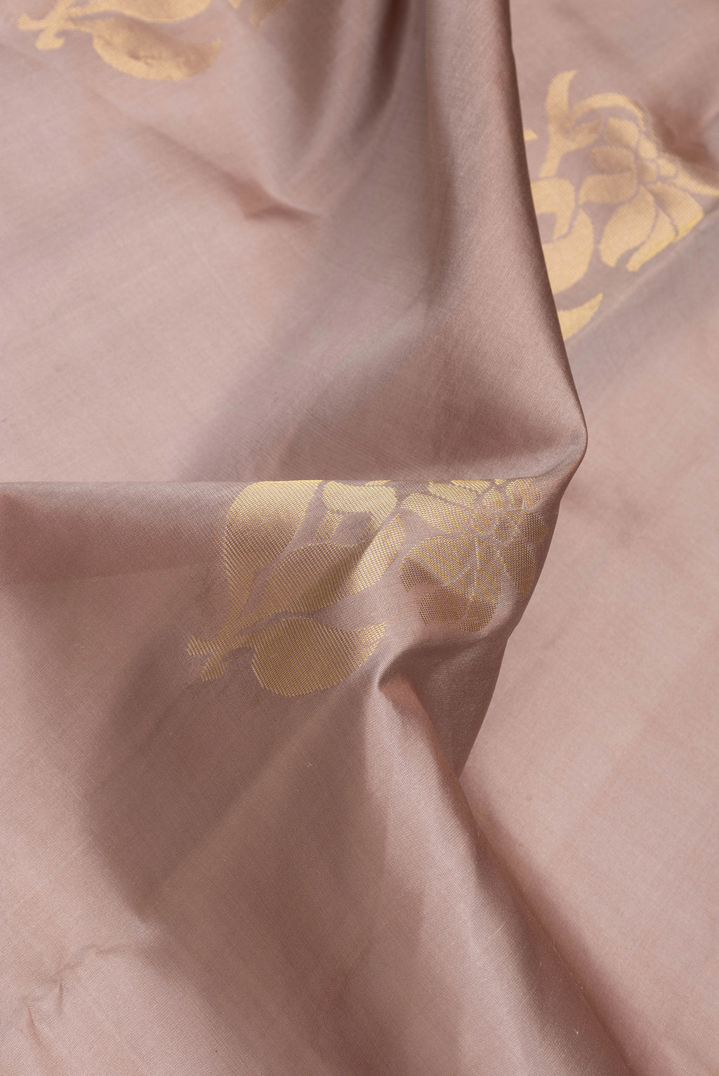 Close up of Brown Dual Tone Soft Silk Saree with Zari Butta on the body and Zari Border.  displaying folds