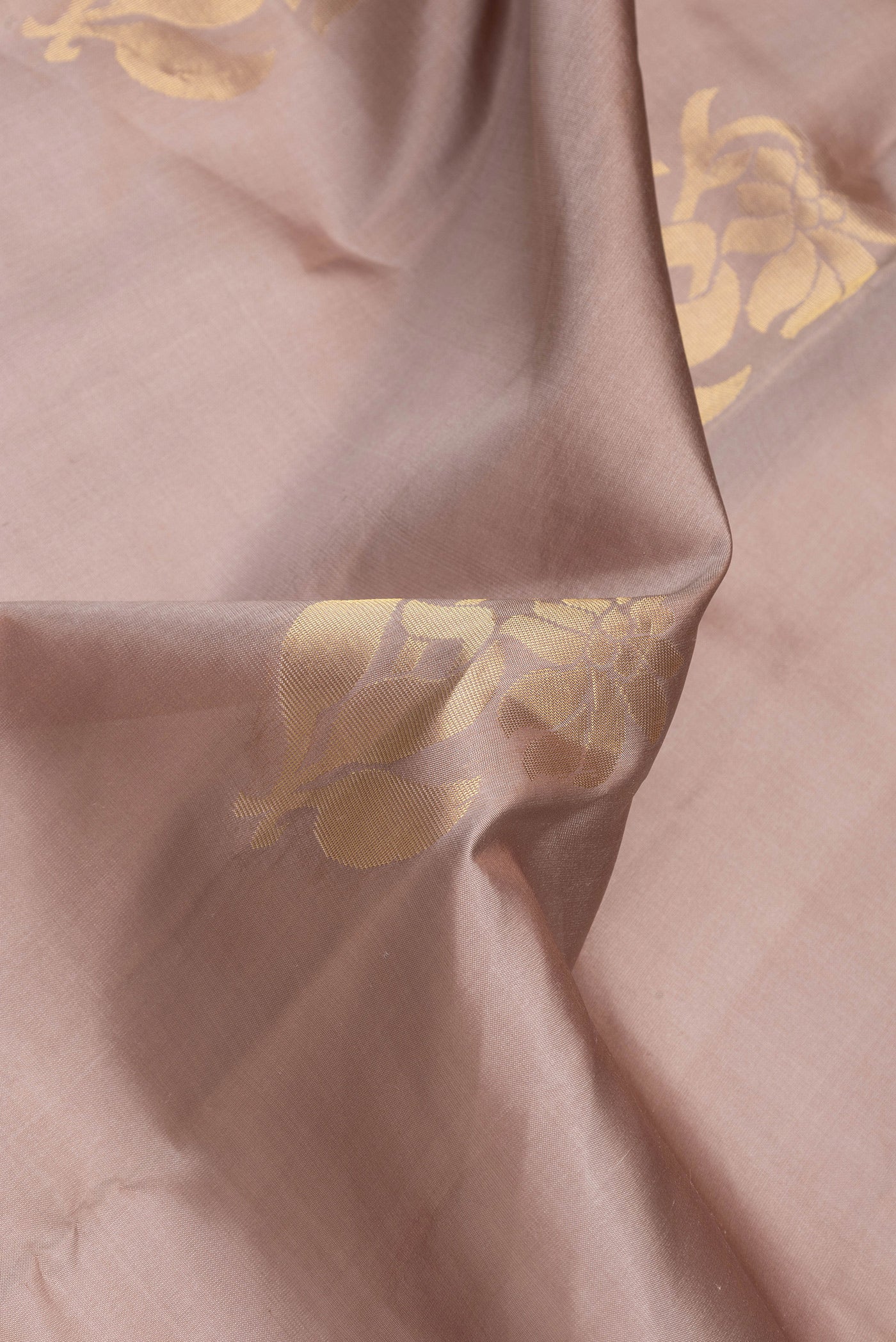 Close up of Brown Dual Tone Soft Silk Saree with Zari Butta on the body and Zari Border.  displaying folds