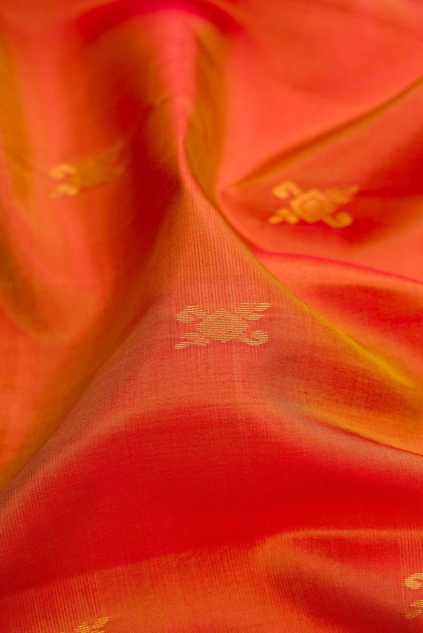 Close up of Brick Orange Dual Tone Soft Silk Saree with Zari Butta on the body and Fancy Border.  displaying folds