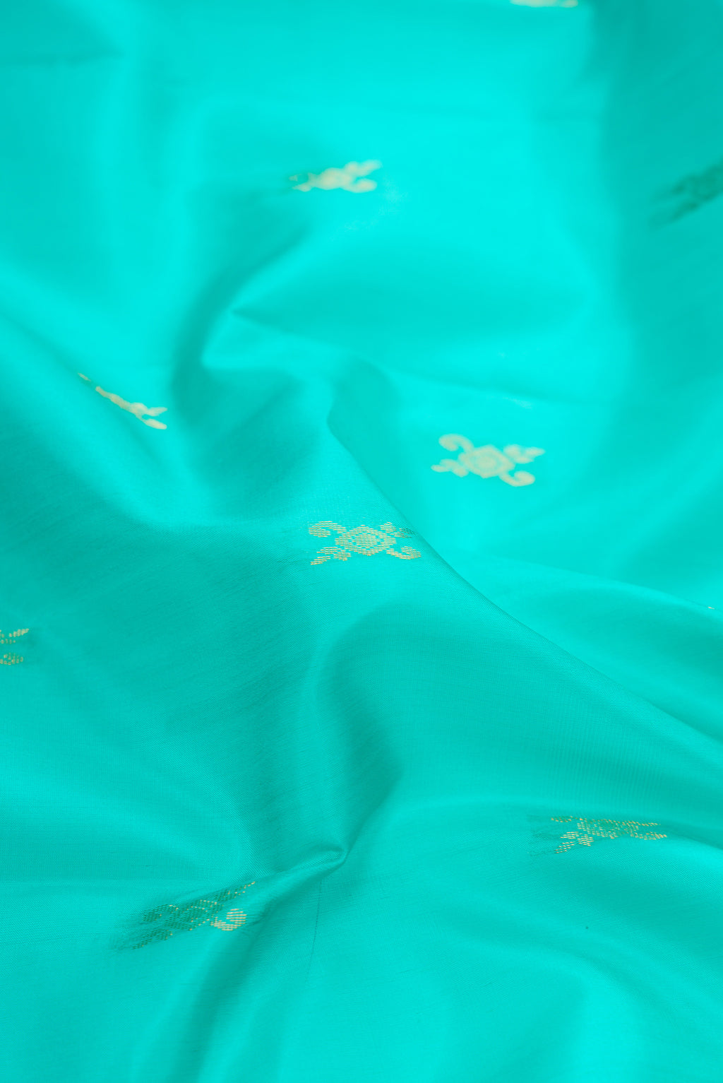Close up of Sky Blue Dual Tone Soft Silk Saree with Zari Butta on the body and Fancy Border.  displaying folds