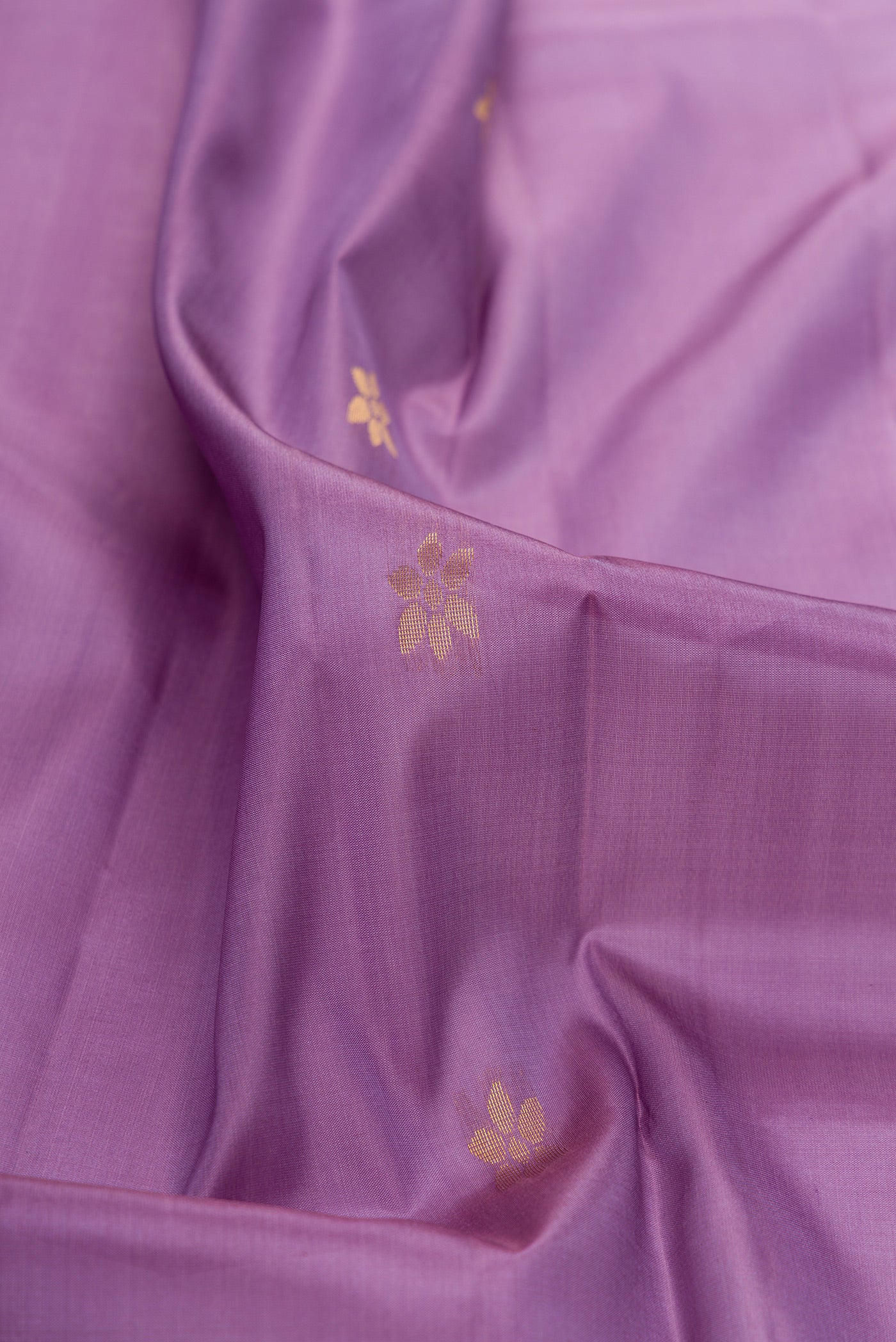 Close up of Lavender Soft Silk Saree with Zari Butta on the body and Fancy Border.  displaying folds