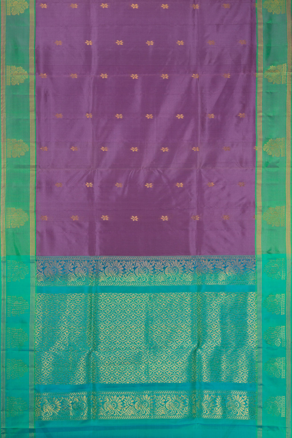 Lavender Soft Silk Saree with Zari Butta on the body and Fancy Border.  displayed on a mannequin