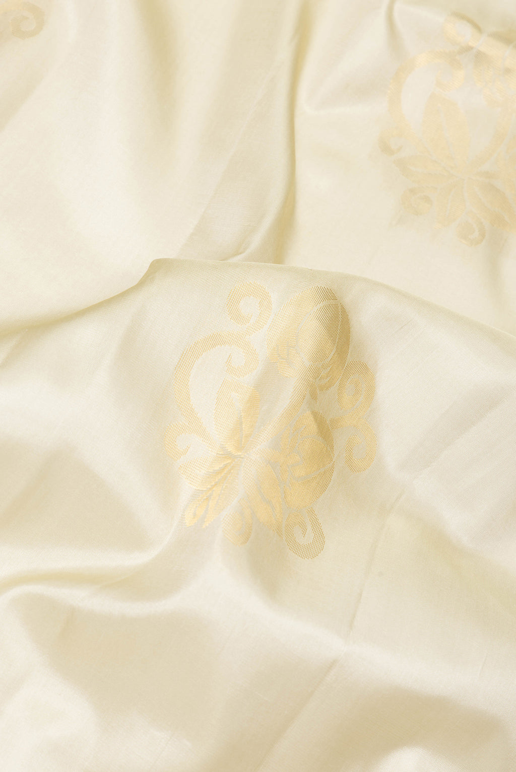 Close up of Beige Soft Silk Saree with Zari Butta on the body and Zari Border.  displaying folds