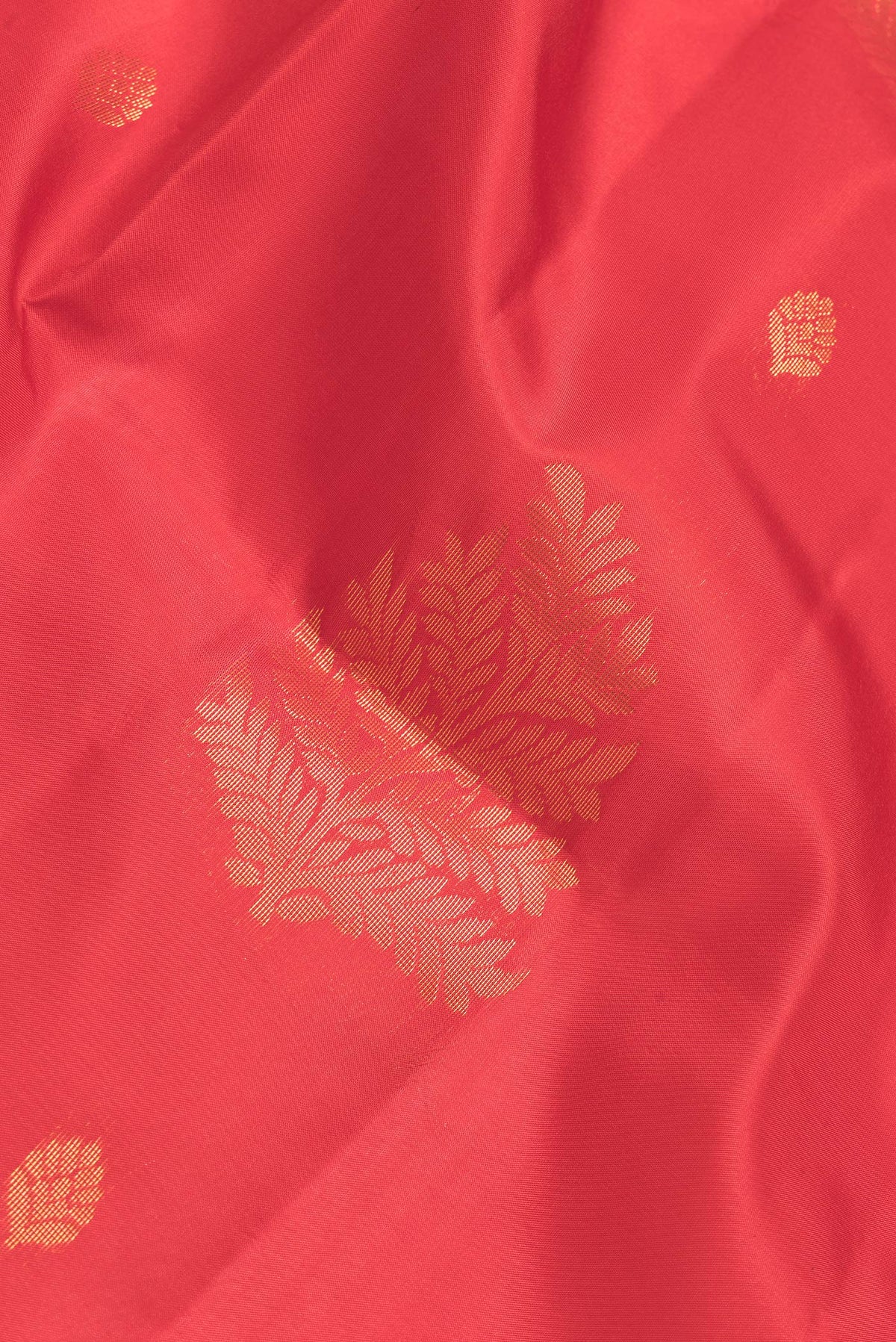Close up of Red Dual Tone Soft Silk Saree with Zari Butta on the body and Fancy Border.  displaying folds