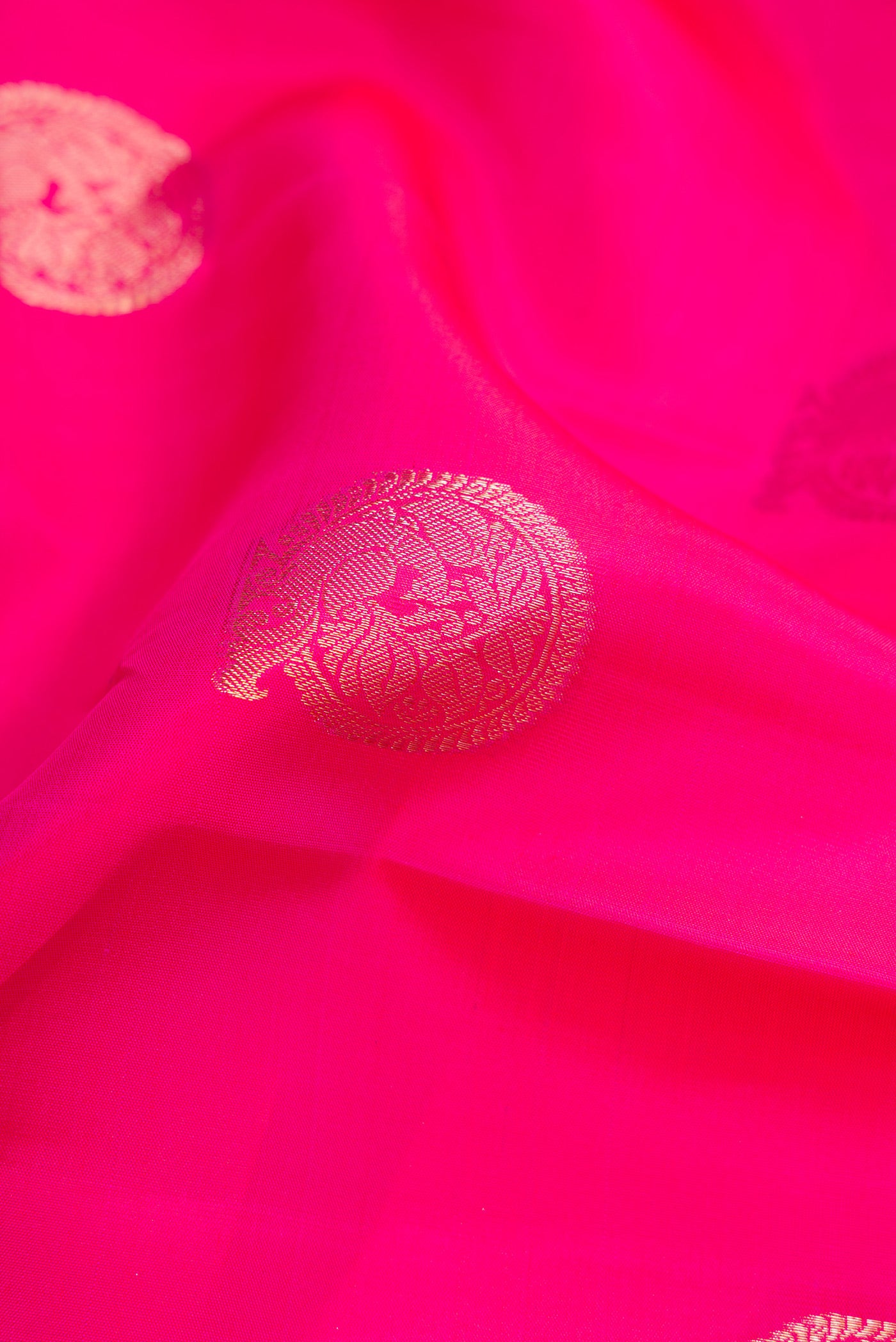 Close up of Pink Dual Tone Kanjivaram Silk Saree with Zari Butta on the body and Zari Border.  displaying folds