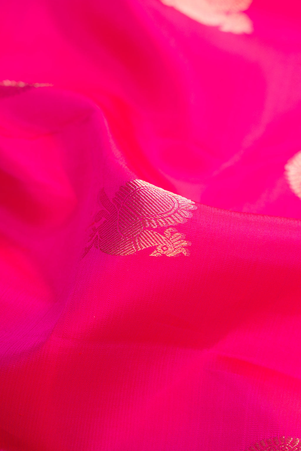 Close up of Pink Dual Tone Kanjivaram Silk Saree with Zari Butta on the body and Zari Border.  displaying folds
